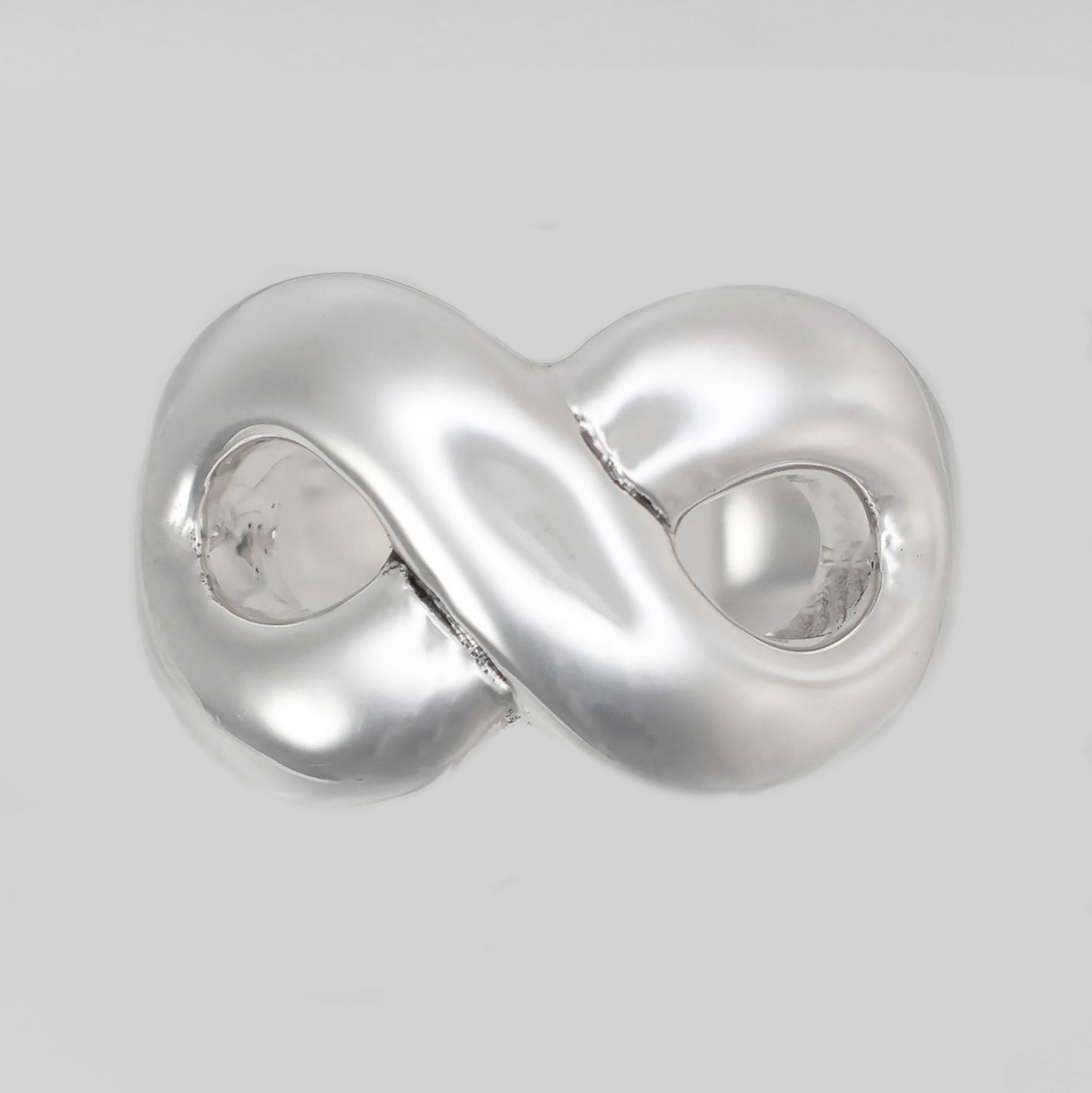 Chunky silver infinity statement ring with a polished finish and unique design for stylish wear