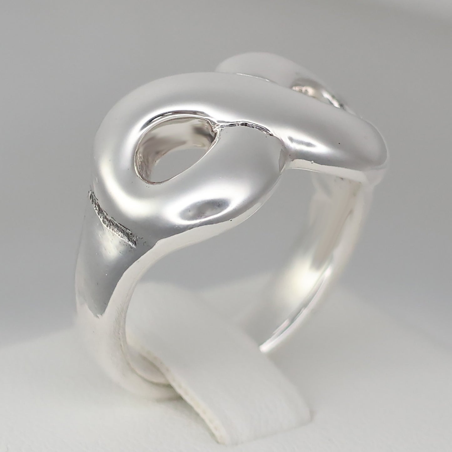 Chunky silver infinity statement ring featuring a smooth, modern design for a stylish look