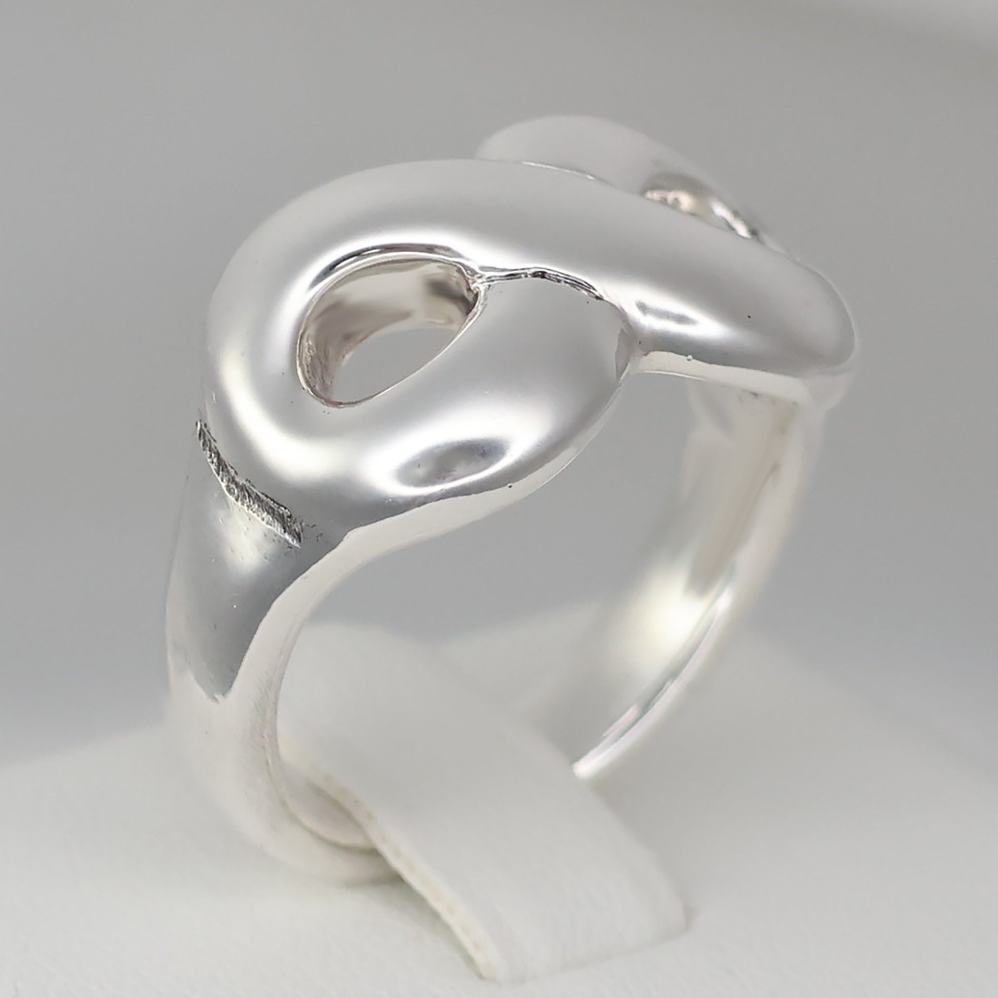 Chunky silver infinity statement ring featuring a smooth, modern design for a stylish look
