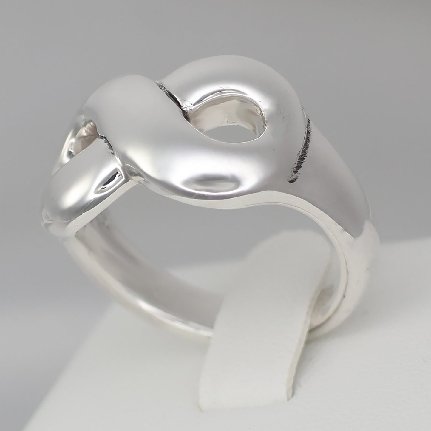 Chunky silver infinity statement ring with a smooth, polished finish for a modern look