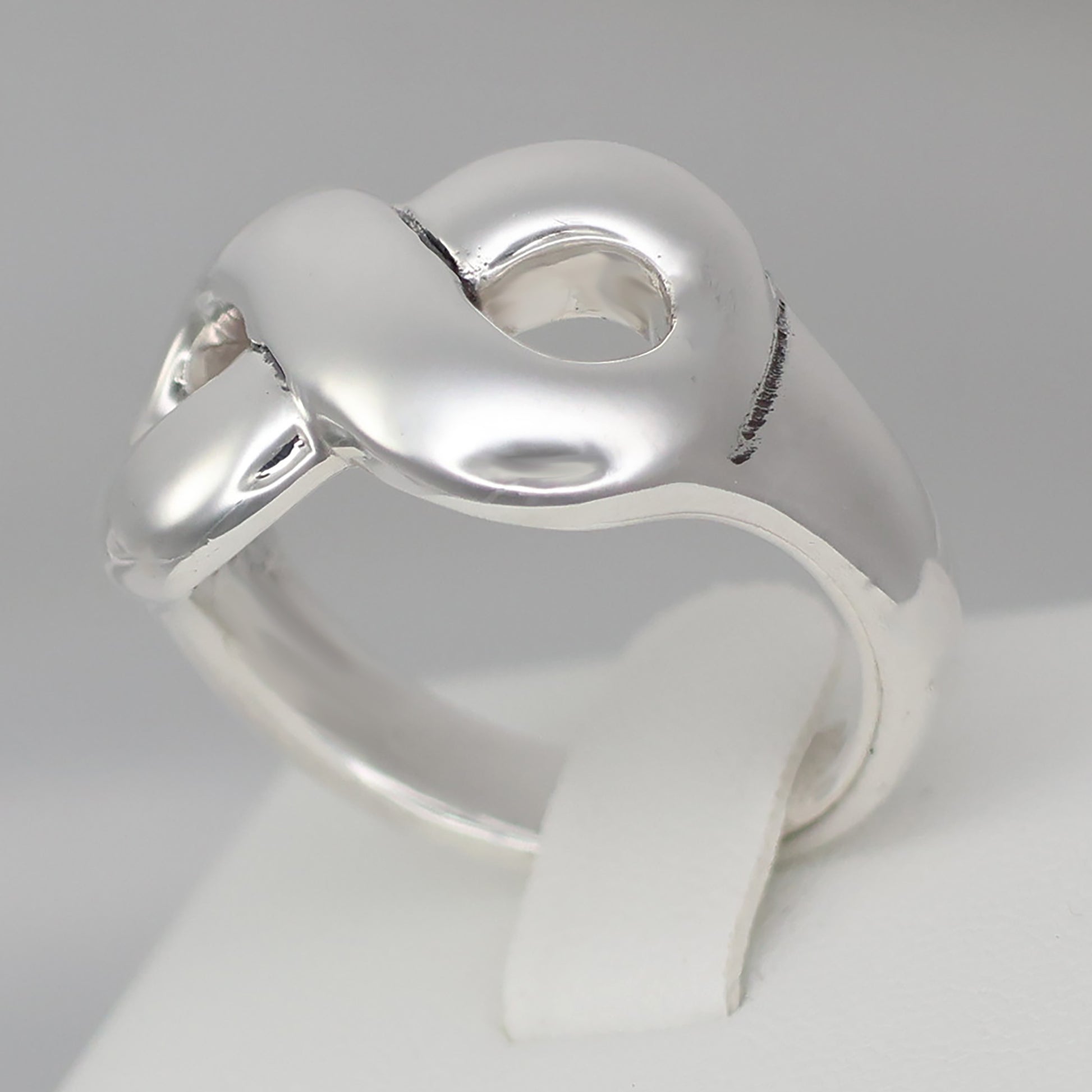 Chunky silver infinity statement ring with a smooth, polished finish for a modern look