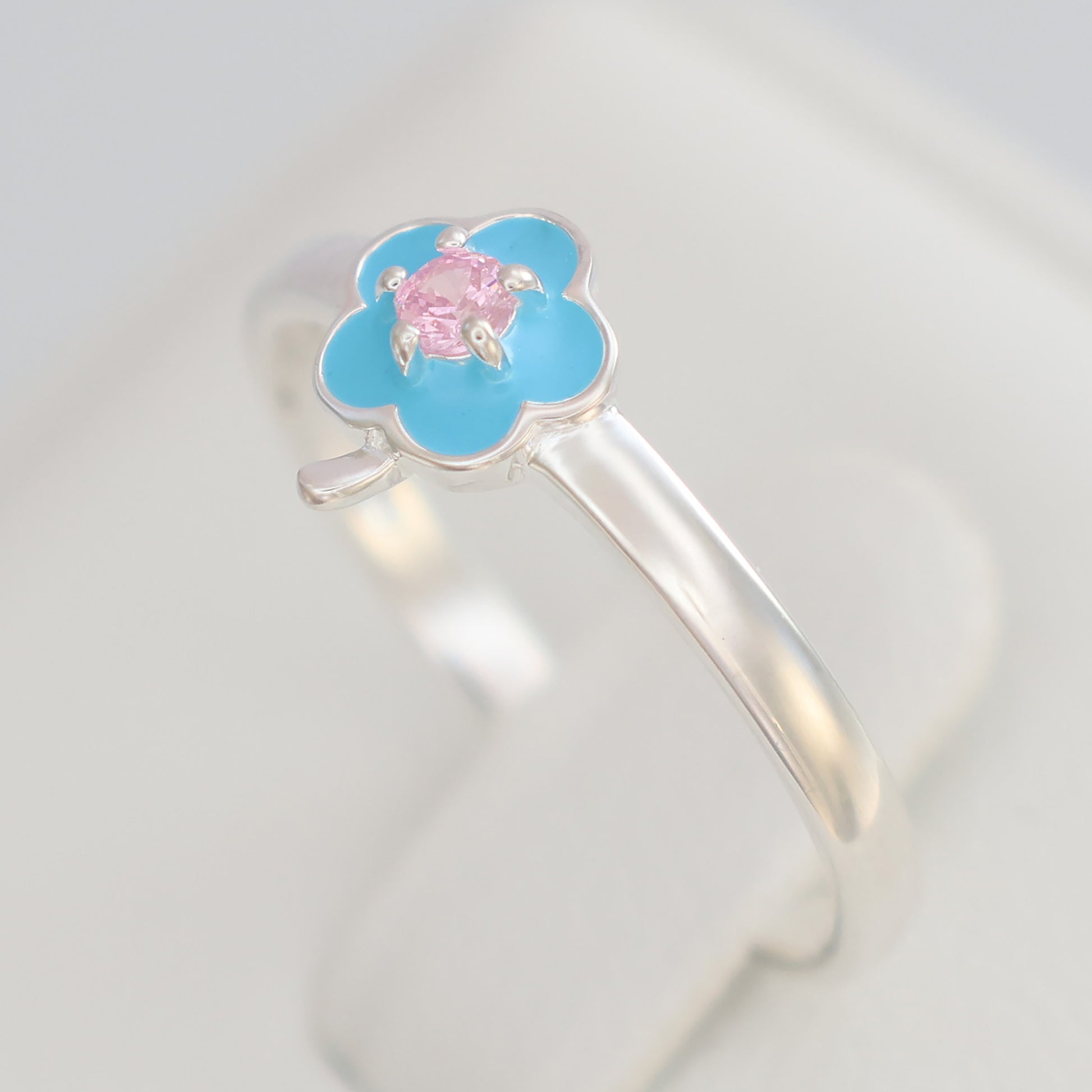 Floral design silver ring featuring a blue flower and pink gemstone center for a delicate look