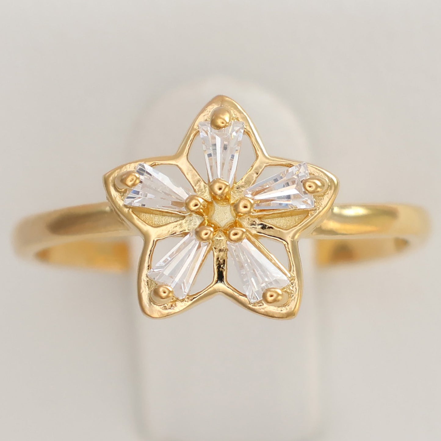 Flower design gold plated ring featuring a delicate star shape with sparkling stones