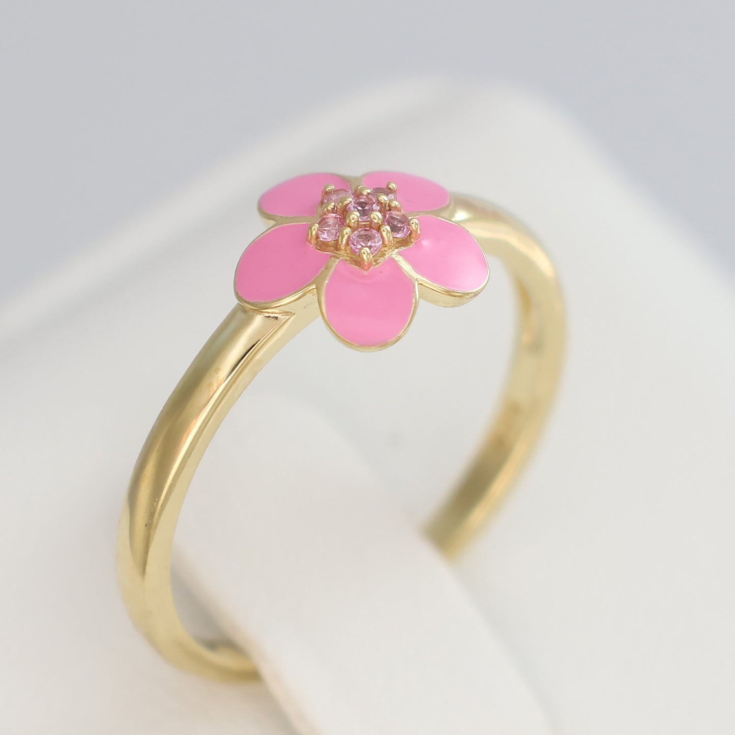 Gold plated pink enamel ring featuring a floral design with sparkling accents