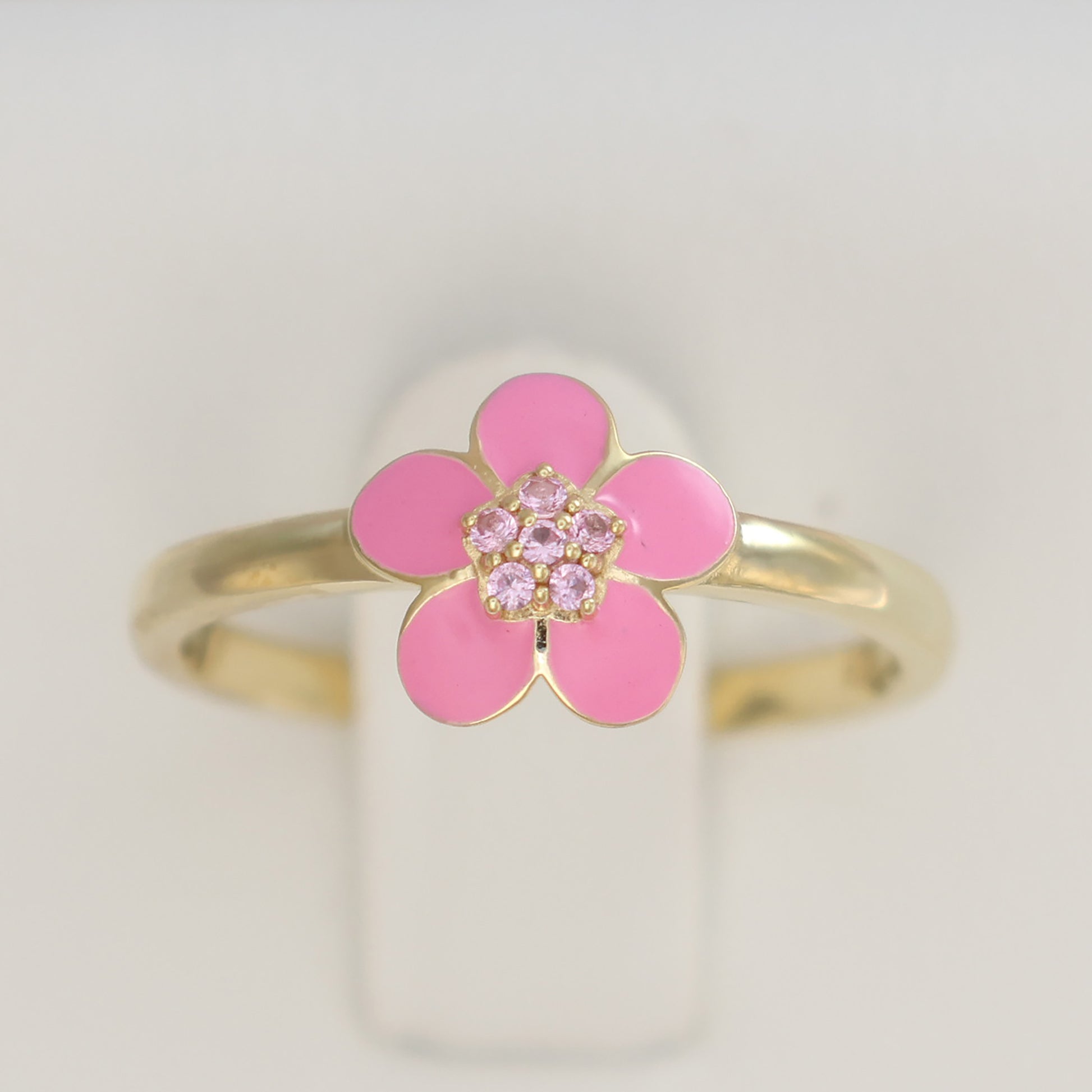Gold plated pink enamel ring featuring a floral design with sparkling details