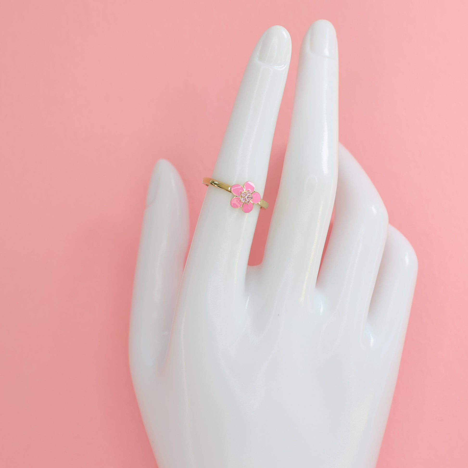 Gold plated pink enamel ring featuring a floral design on a delicate band