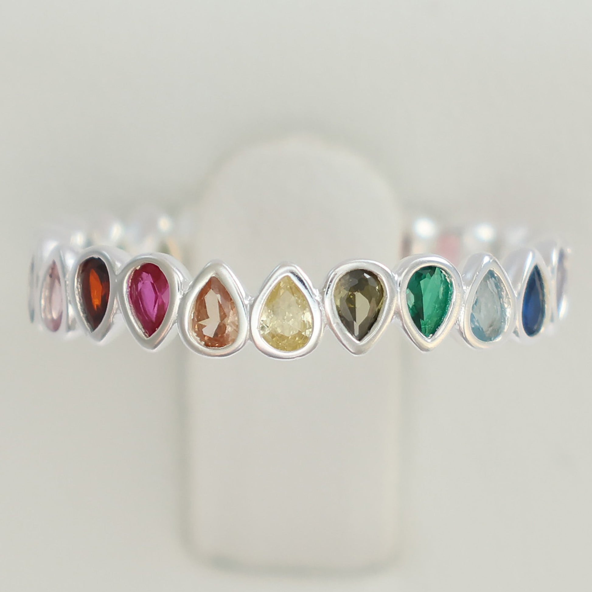 Multi colour rainbow cubic zirconia eternity ring featuring teardrop gemstones in various colors