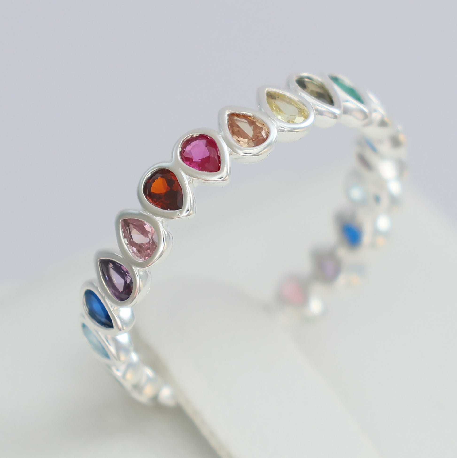 Multi colour rainbow cubic zirconia eternity ring in silver featuring a variety of vibrant gemstones