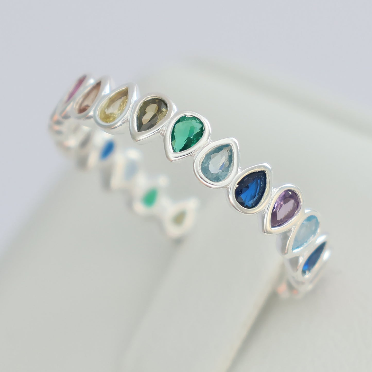 Multi colour rainbow cubic zirconia eternity ring with charming teardrop design and silver band