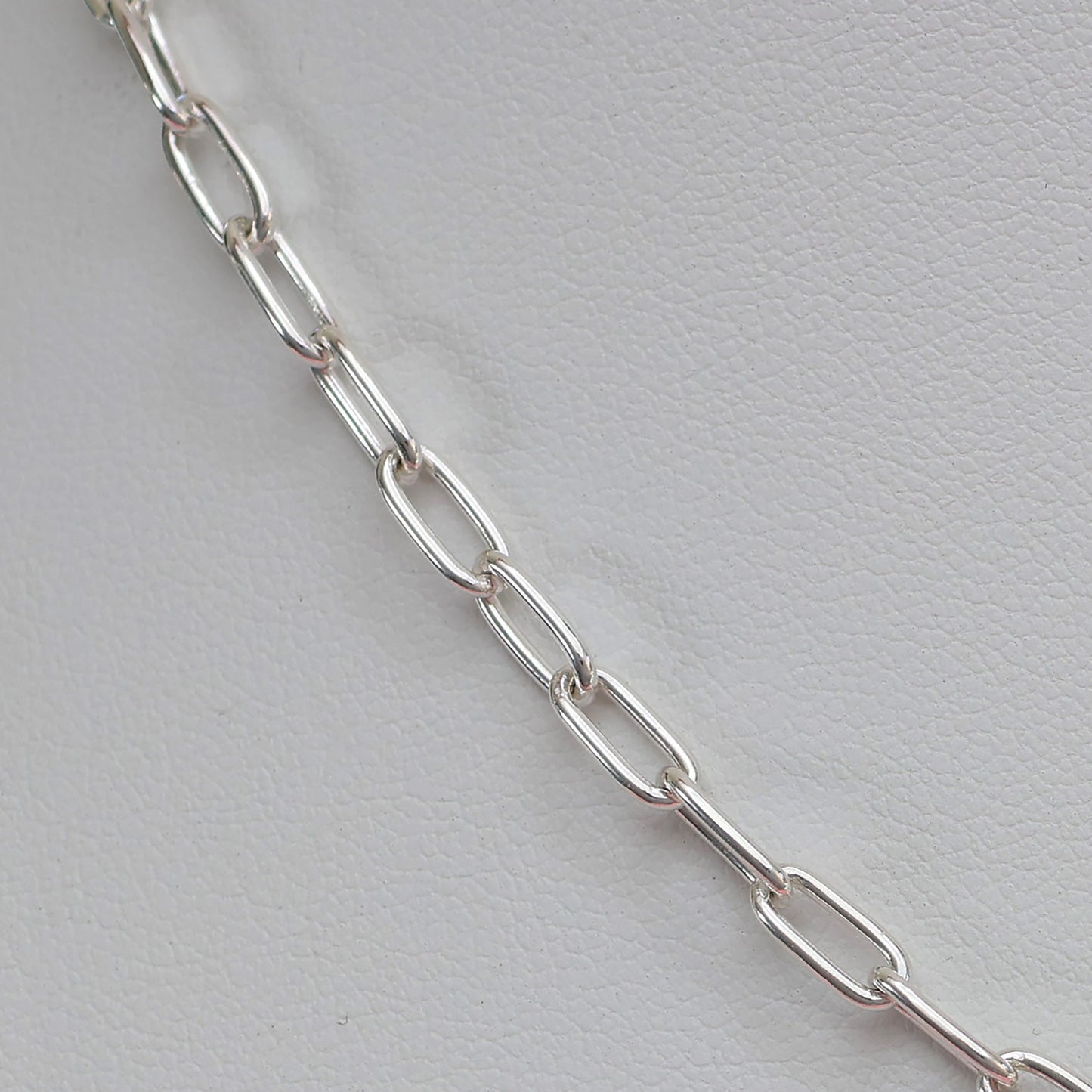 Close-up of a padlock clasp silver necklace with sleek, elongated chain links