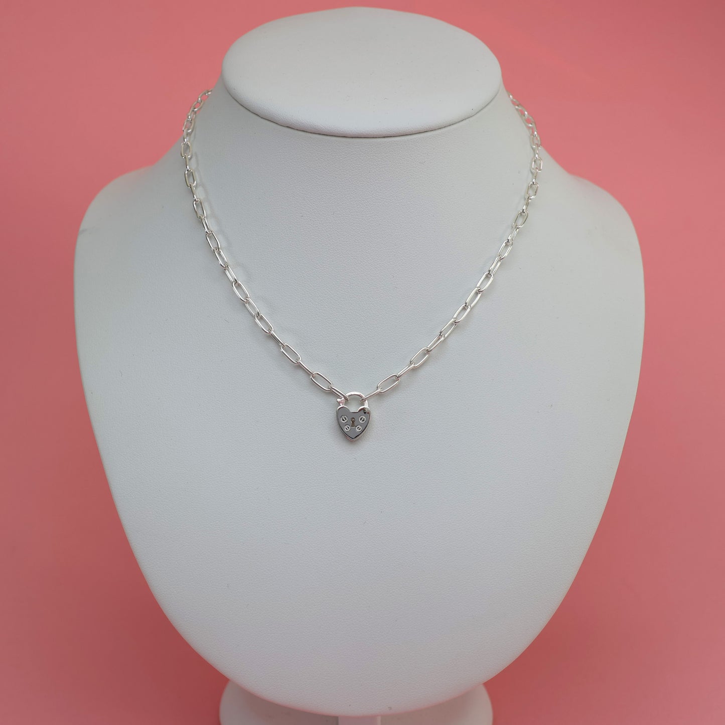 Stylish padlock clasp silver necklace displayed on a white jewelry stand