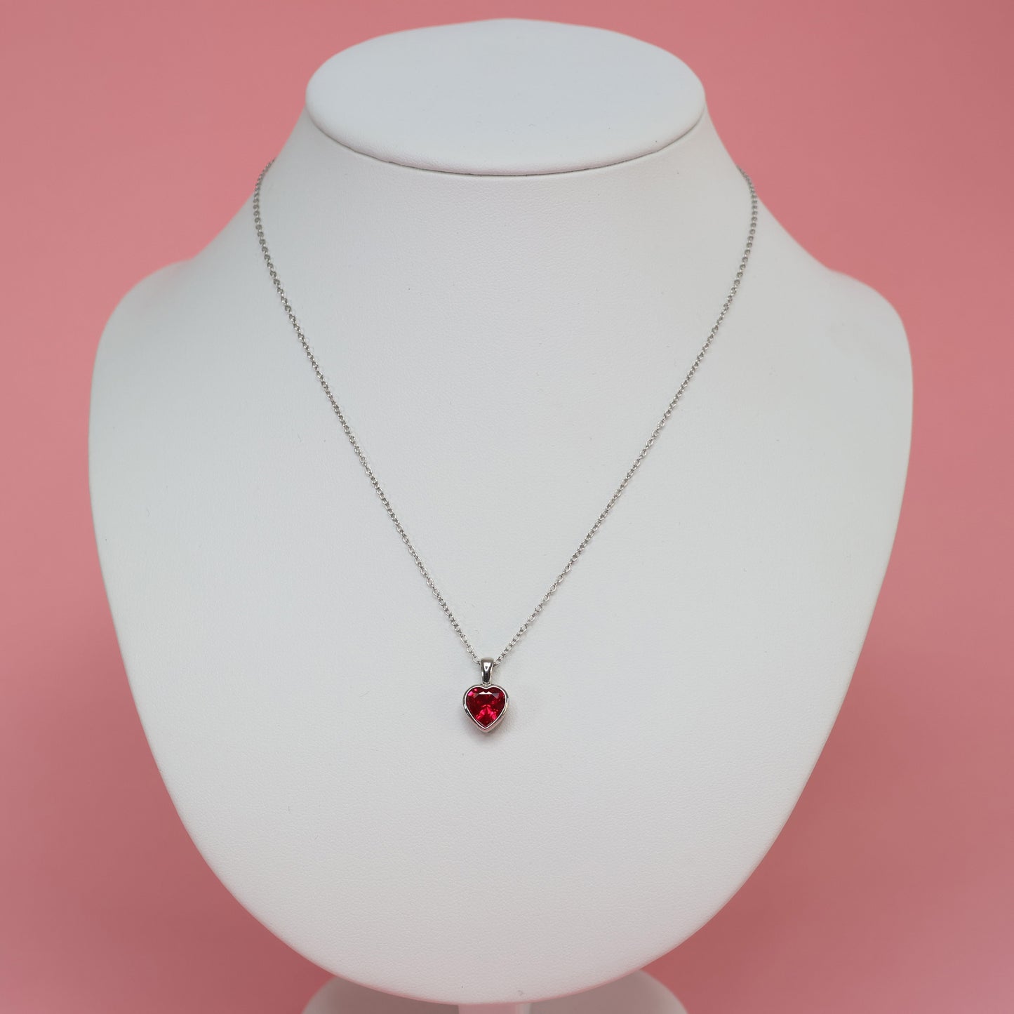 Stylish red heart cubic zirconia pendant on a silver chain displayed on a jewelry bust