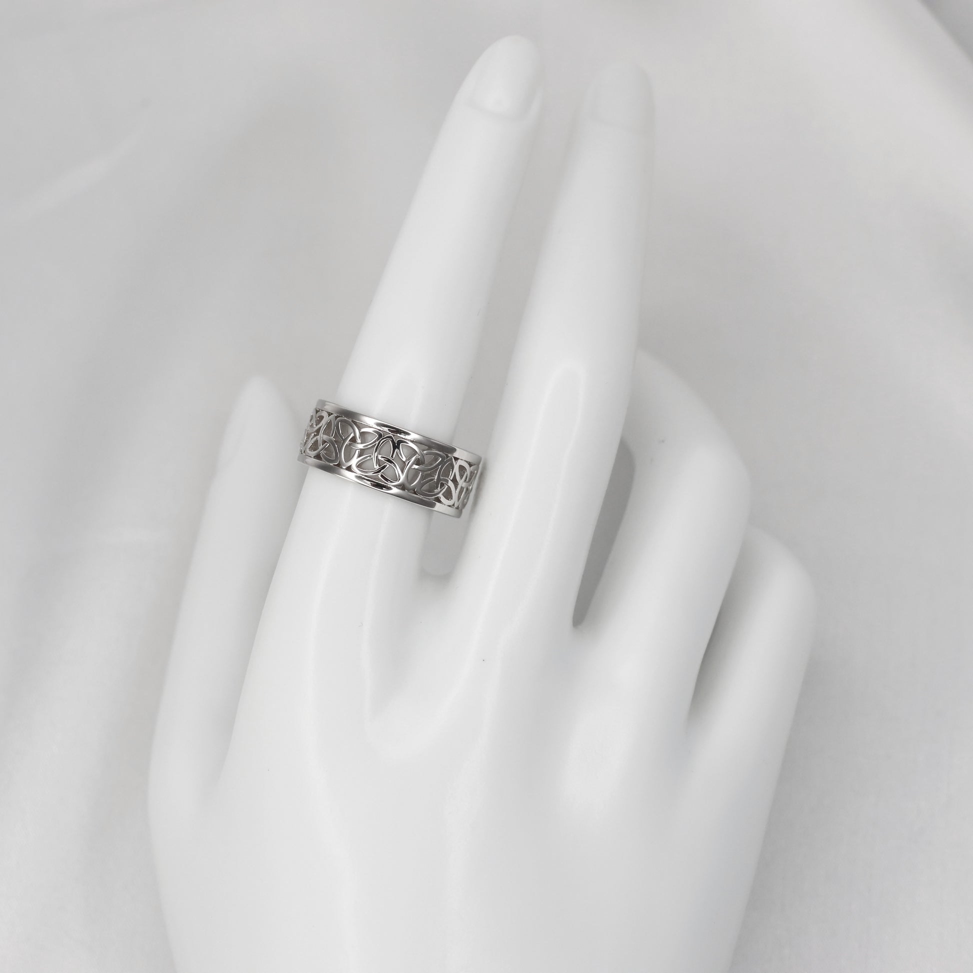 Silver Celtic band ring displayed on a mannequin hand showcasing intricate design