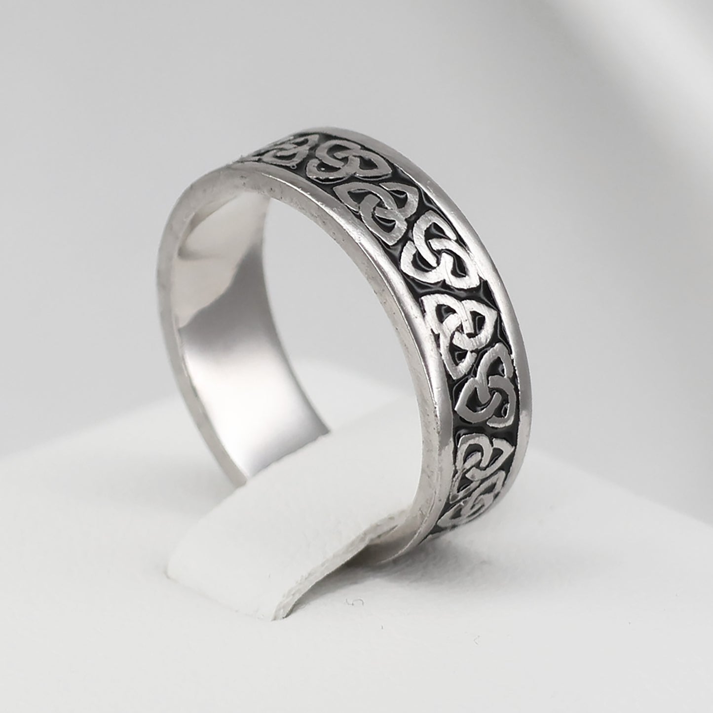 Silver Celtic band ring featuring intricate knot designs for a timeless look