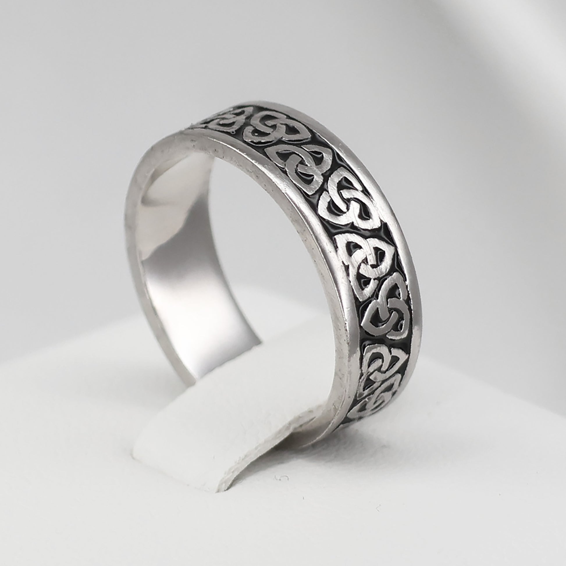 Silver Celtic band ring featuring intricate knot designs for a timeless look