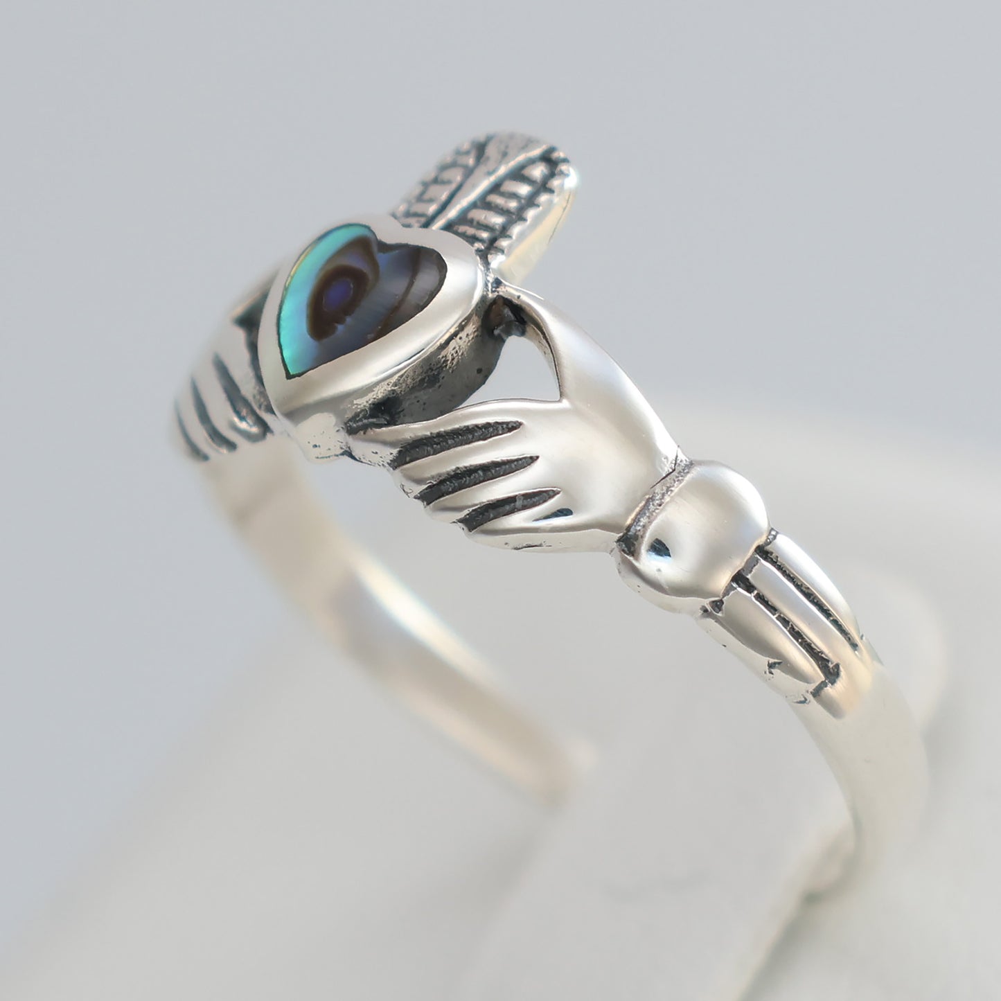Elegant silver claddagh ring featuring a unique design and a gemstone centerpiece