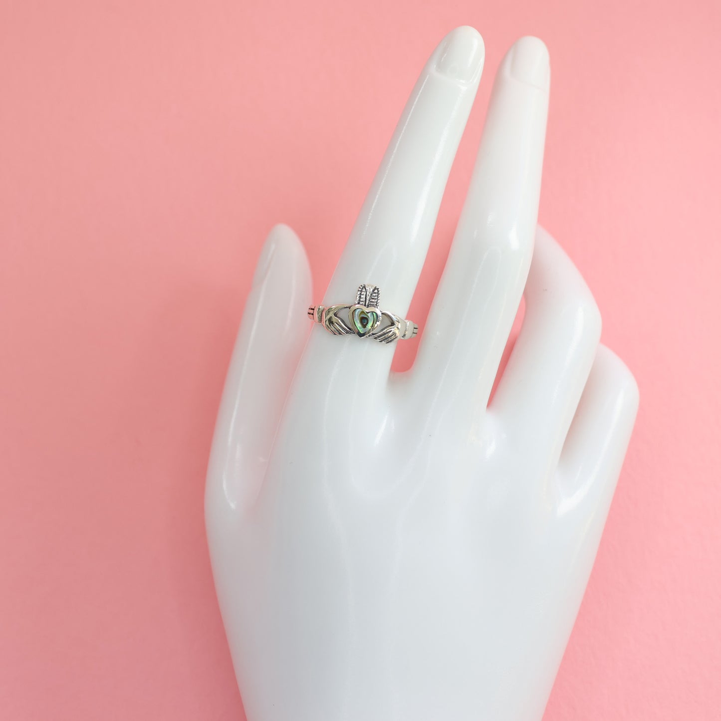 Silver claddagh ring displayed on a hand model showcasing its unique design and craftsmanship