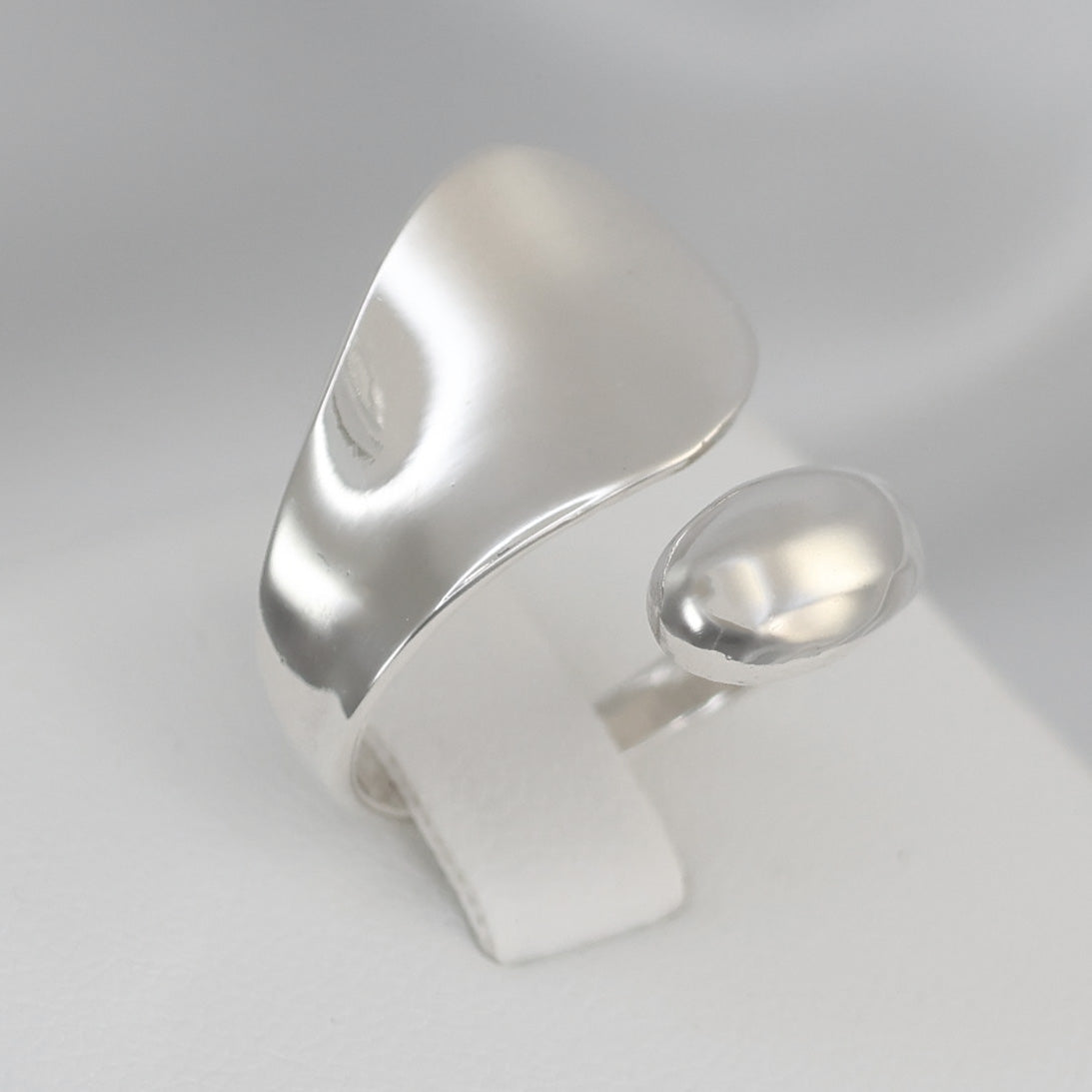 Stylish silver crossover ring UK featuring a smooth, modern design for trendy accessories