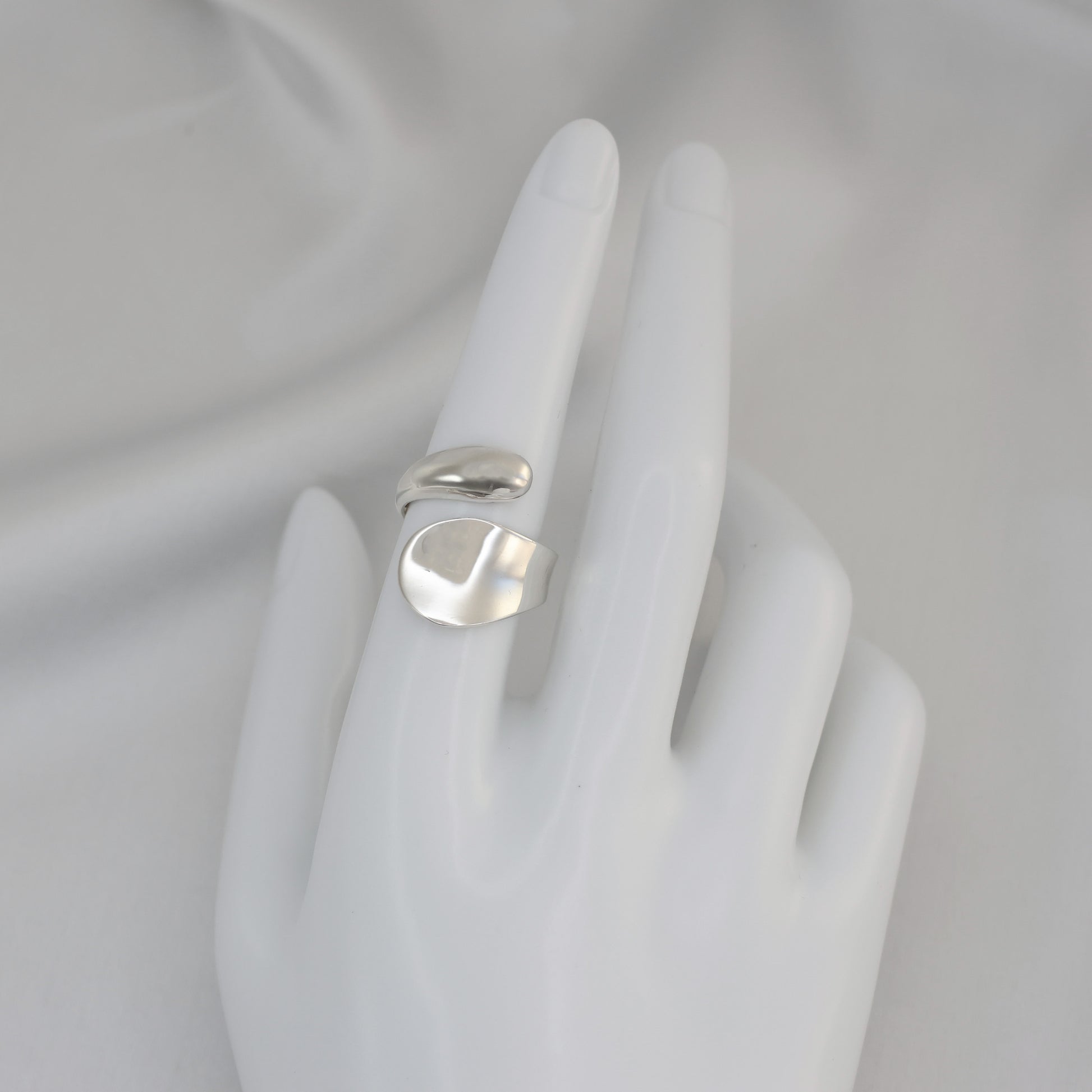 Stylish silver crossover ring UK displayed on a mannequin hand for elegant fashion looks
