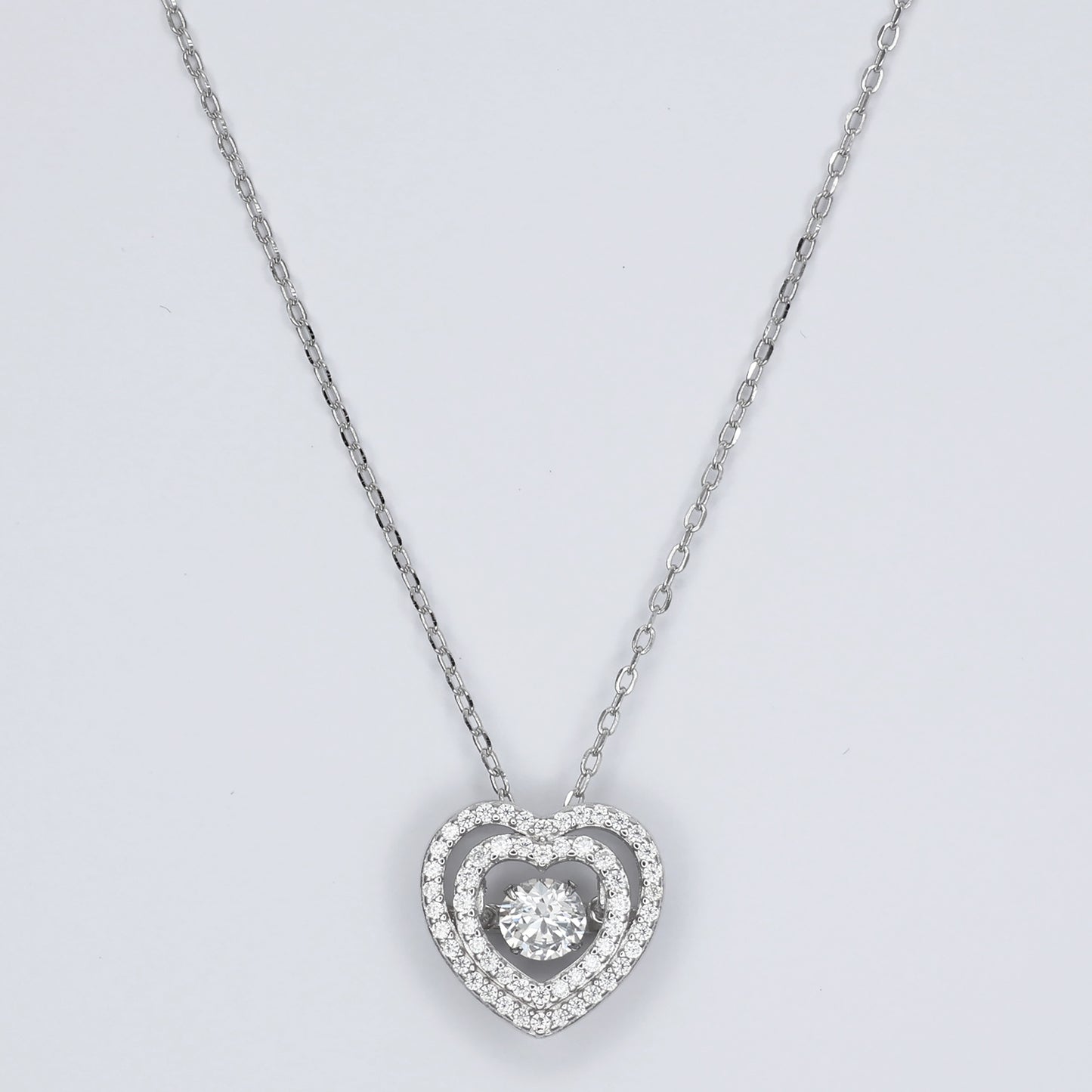 Elegant silver heart pendant necklace with sparkling center stone, perfect for romantic occasions