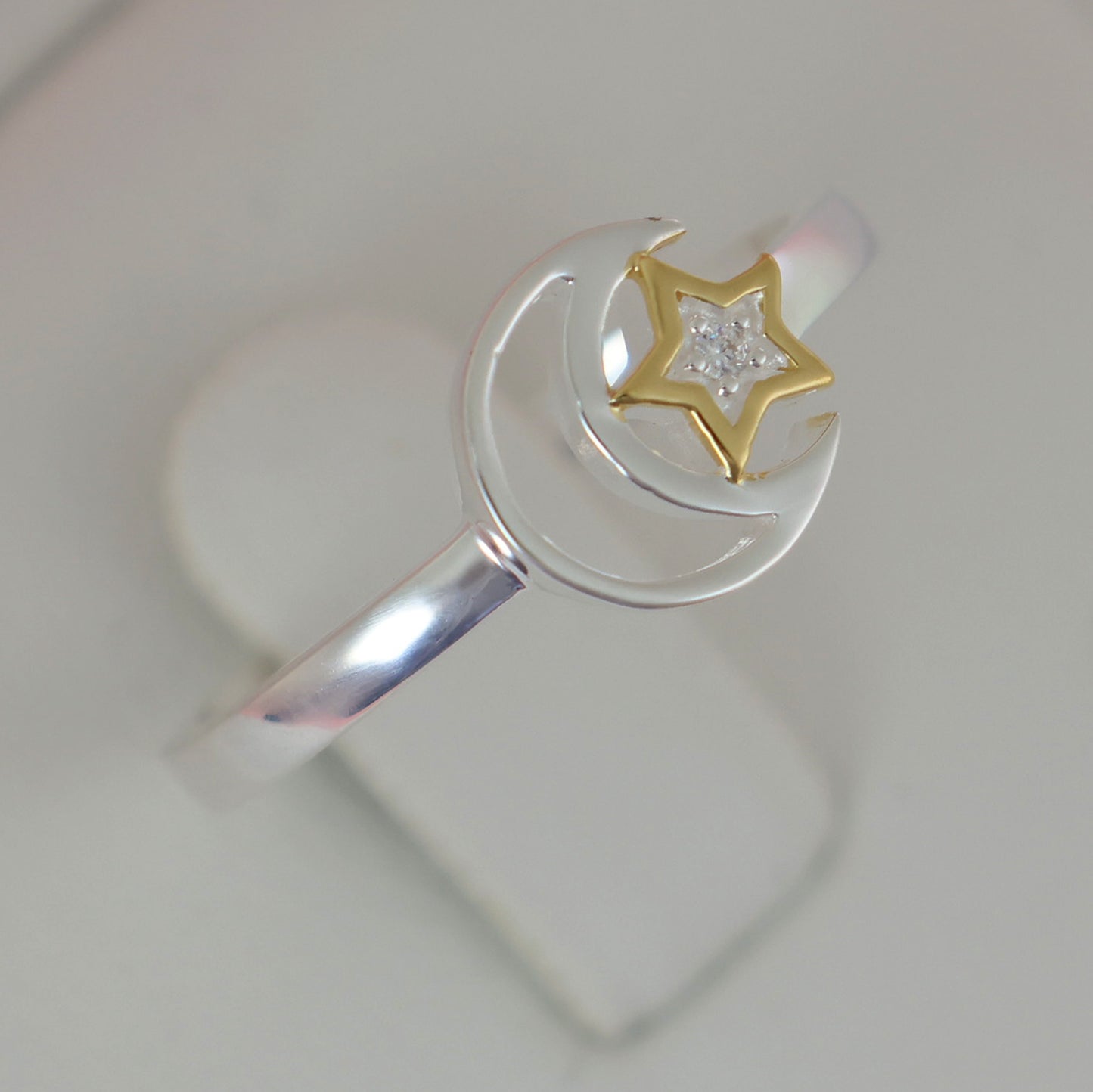 Elegant silver moon and star ring featuring a gold star and sparkling details for a celestial touch