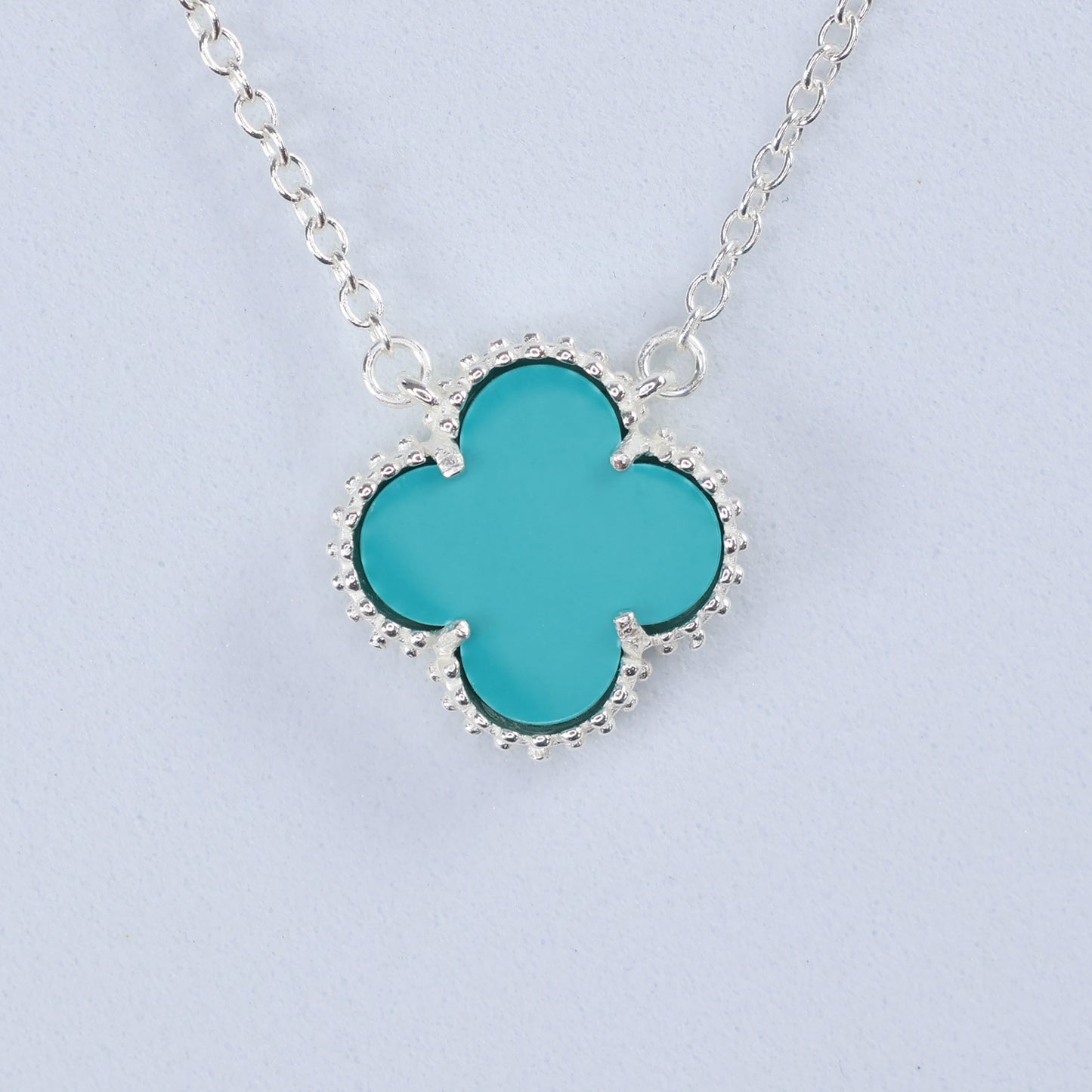 Silver necklace with blue clover pendant featuring a unique design for elegant style