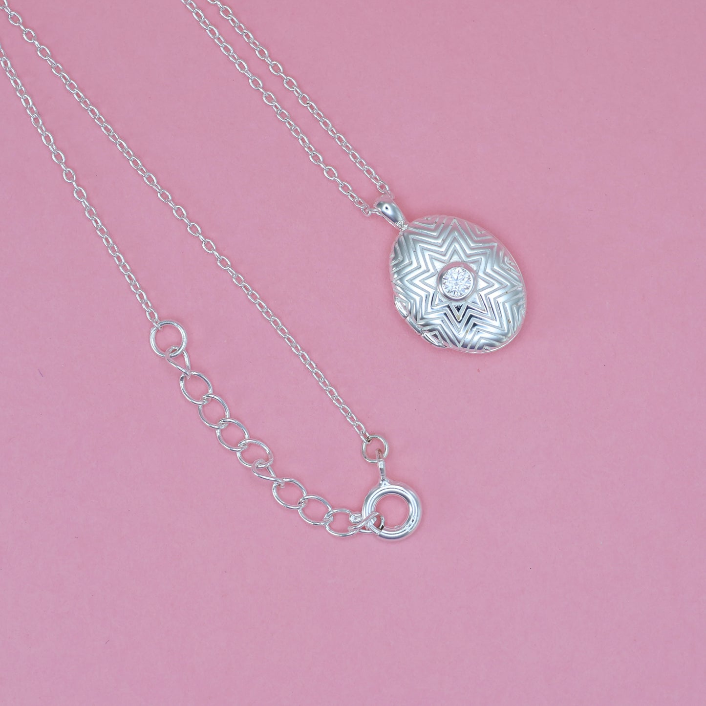 Stunning silver oval locket necklace featuring intricate design and a sparkling centerpiece