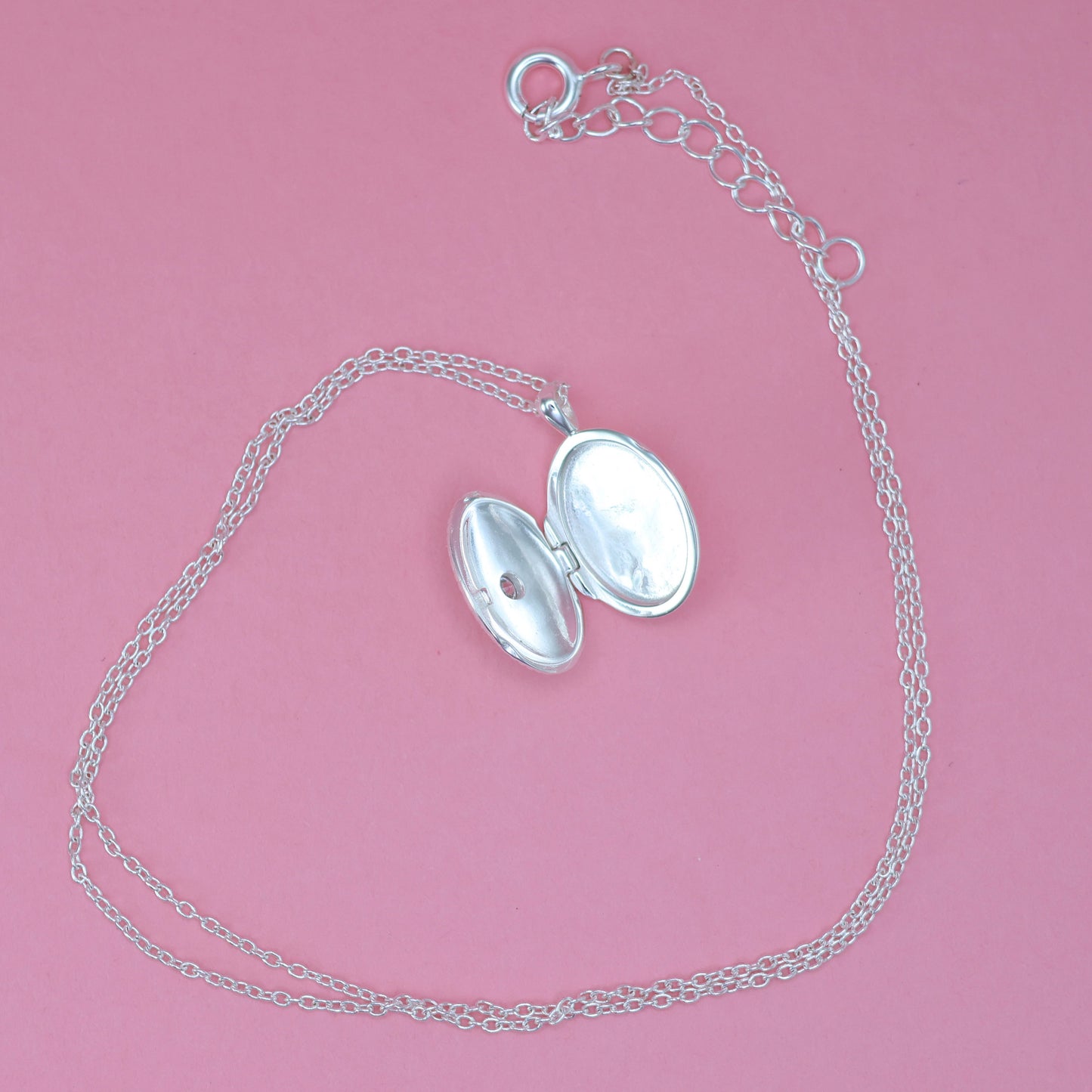 Silver oval locket necklace featuring an elegant design with an opening for cherished photos