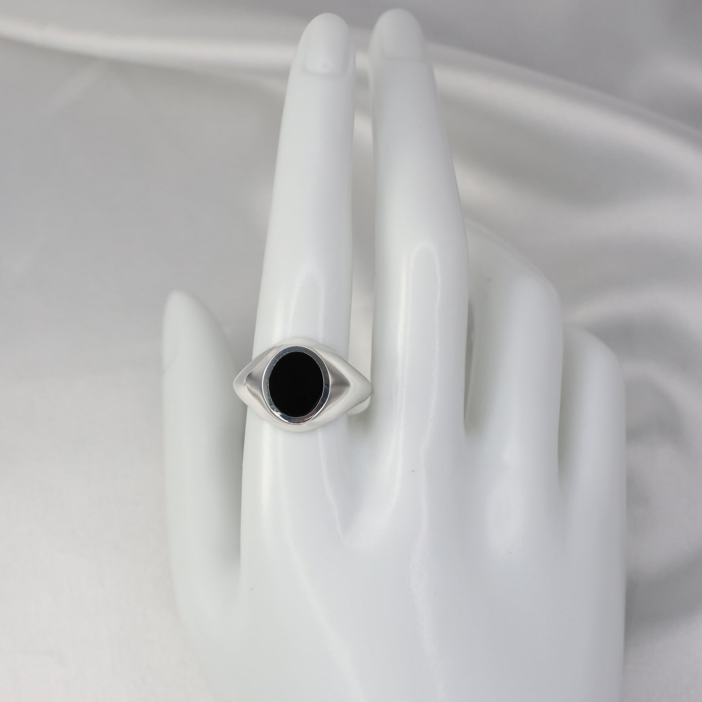 Silver signet ring with an eye design and black stone in a polished finish