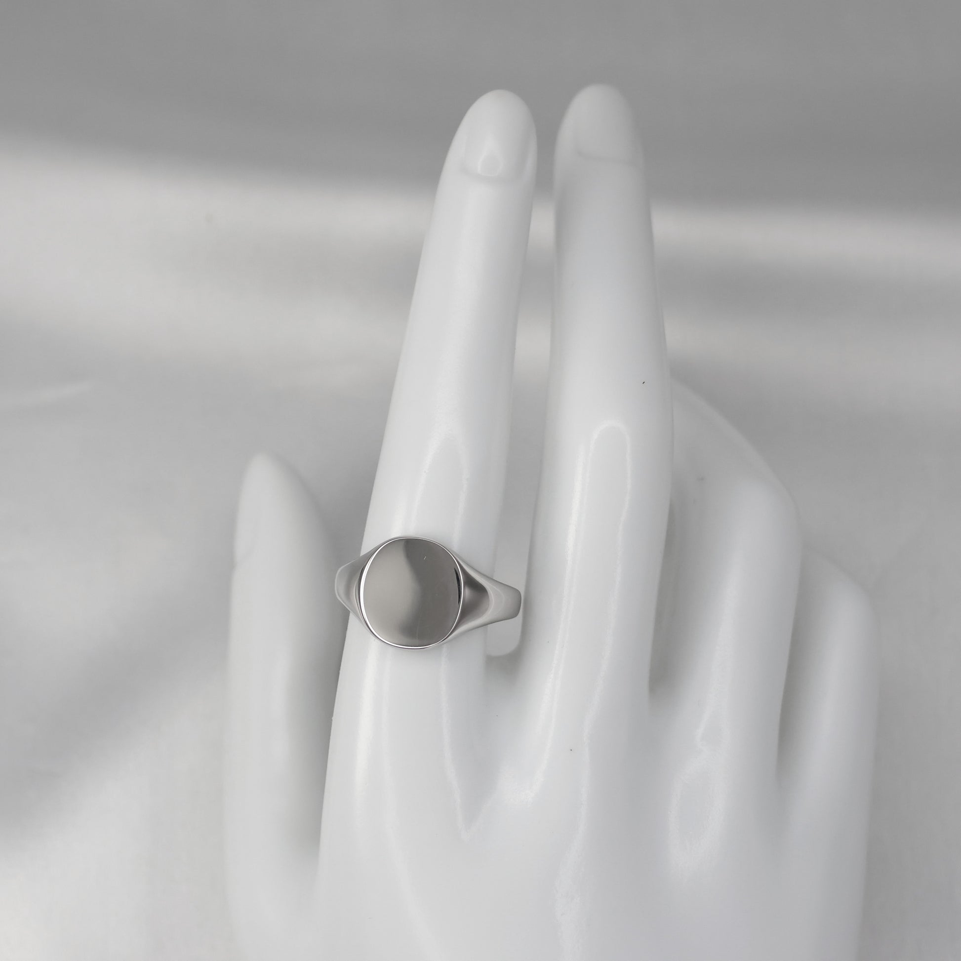 Elegant silver signet ring size R displayed on a hand model with a polished surface