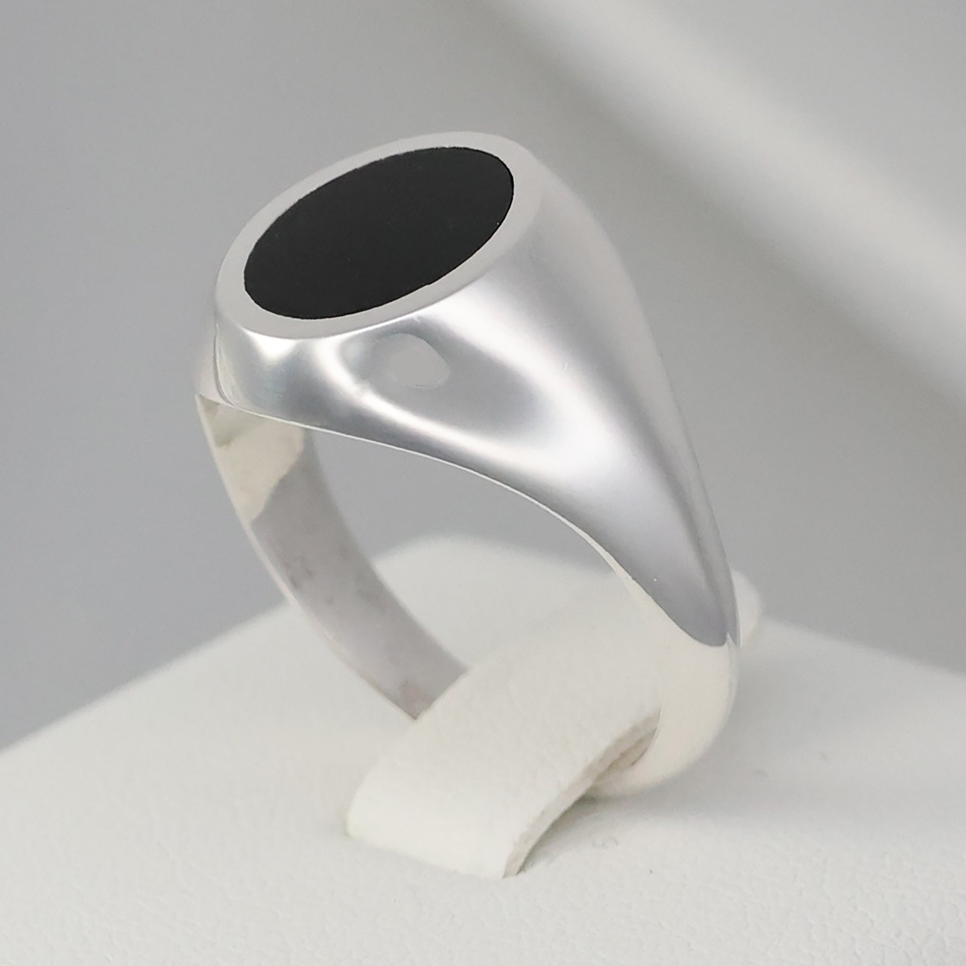 Elegant silver signet ring with a smooth black stone in a sleek design