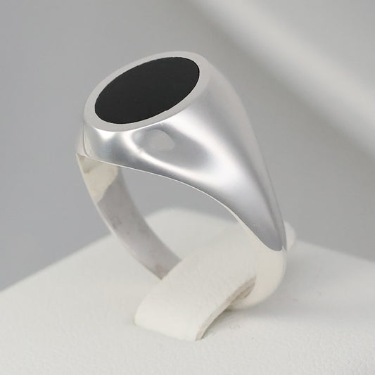 Elegant silver signet ring with a smooth black stone in a sleek design