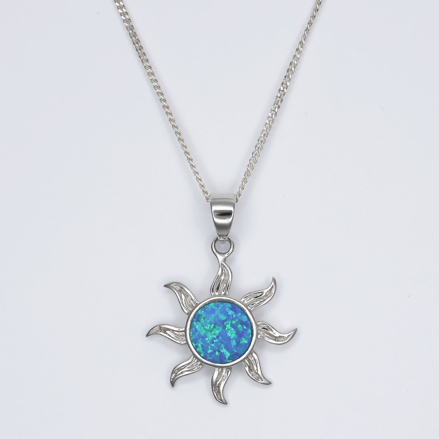 Silver sunshine pendant featuring an iridescent blue center and artistic sunray design on a chain