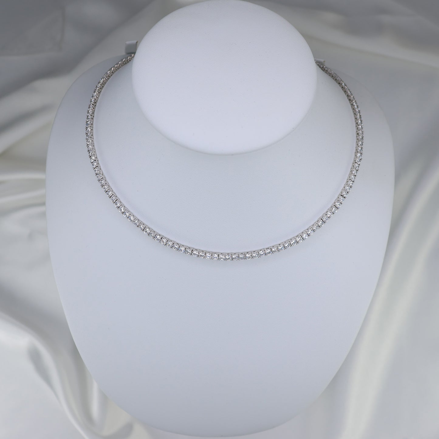 Elegant silver tennis necklace on display, featuring sparkling gemstones for a timeless look