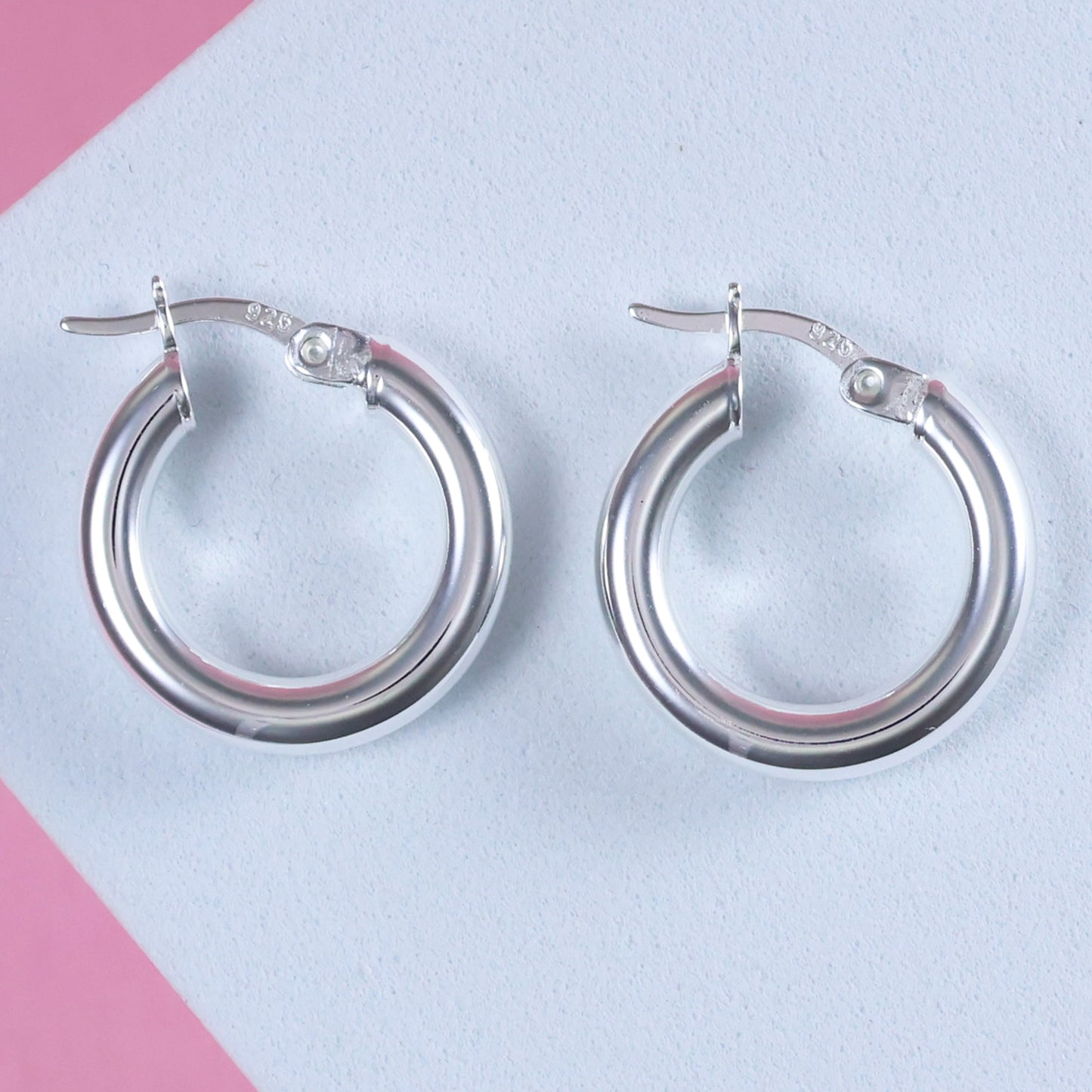 Elegant small 15mm silver hoop earrings with a polished finish and secure clasp
