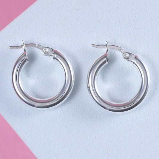 Elegant small 15mm silver hoop earrings with a polished finish and secure clasp