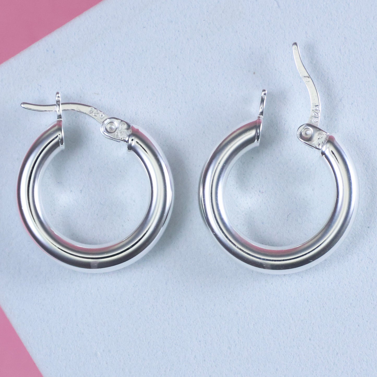 Elegant small 15mm silver hoop earrings with a polished finish for versatile styling