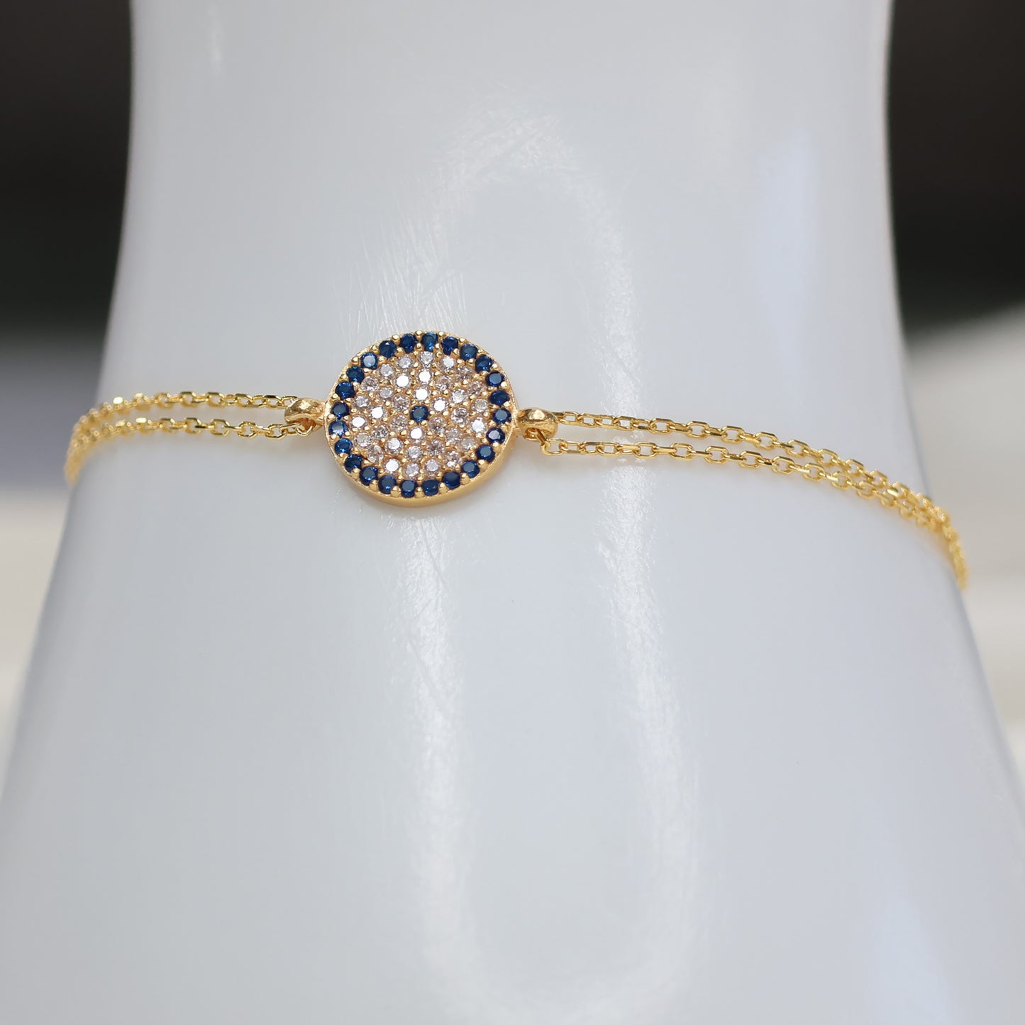 Gold plated evil eye bracelet with blue and clear stones, perfect for stylish protection.