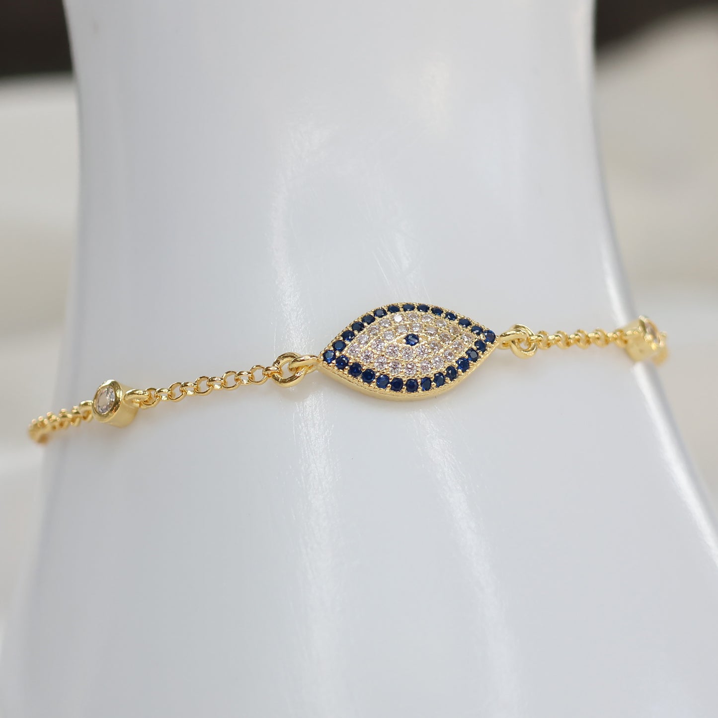 Gold plated evil eye bracelet featuring sparkling blue and clear stones on a delicate chain