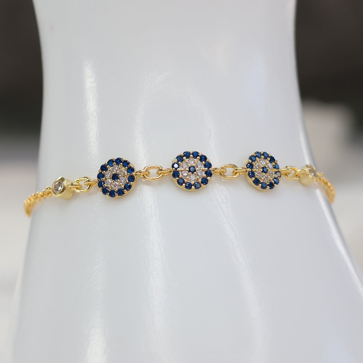 Gold plated evil eye bracelet featuring intricate circular charms for stylish protection