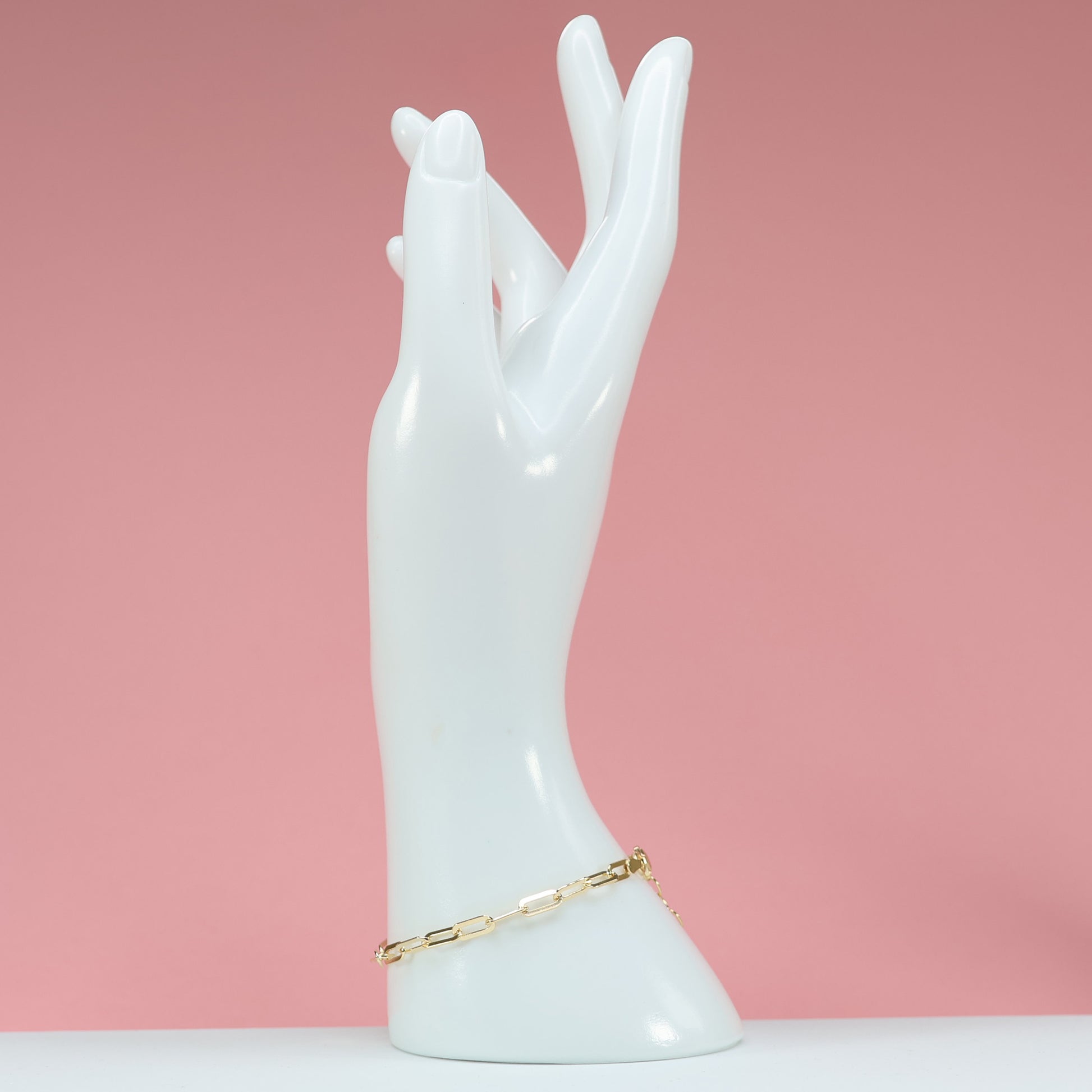 Elegant gold plated paperclip bracelet displayed on a chic hand sculpture