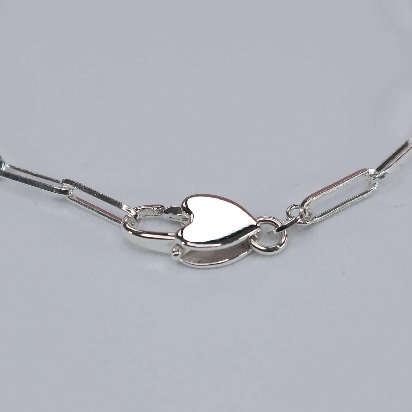 Heart clasp silver bracelet featuring a delicate chain design and a stylish heart clasp