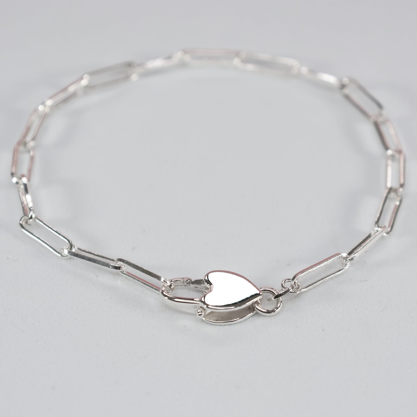 Elegant heart clasp silver bracelet featuring a delicate link design for everyday wear