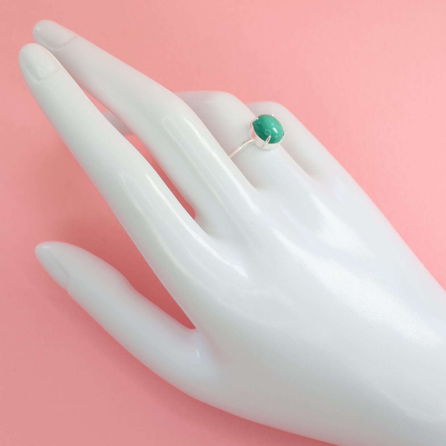Elegant large malachite stone ring set on a display hand with a simple design
