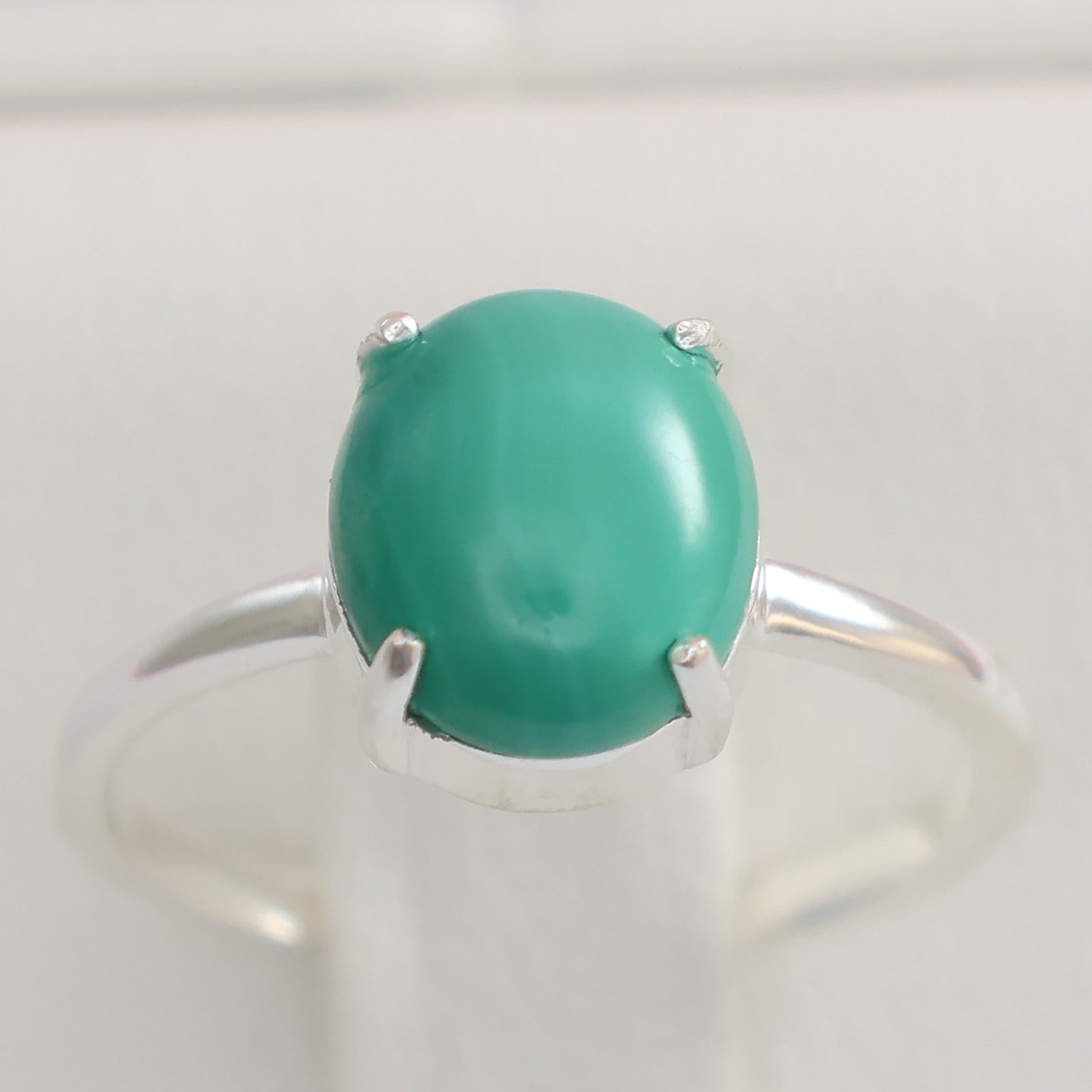 Large malachite stone ring with a silver band showcasing the vibrant green hue of the stone
