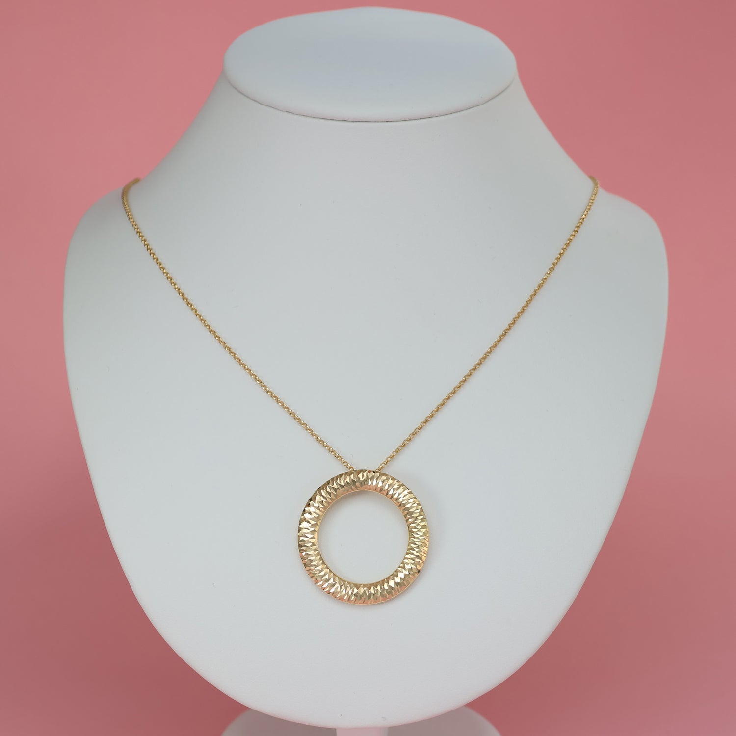 Elegant large ring hoop halo pendant in gold on a delicate chain, displayed on a jewelry stand