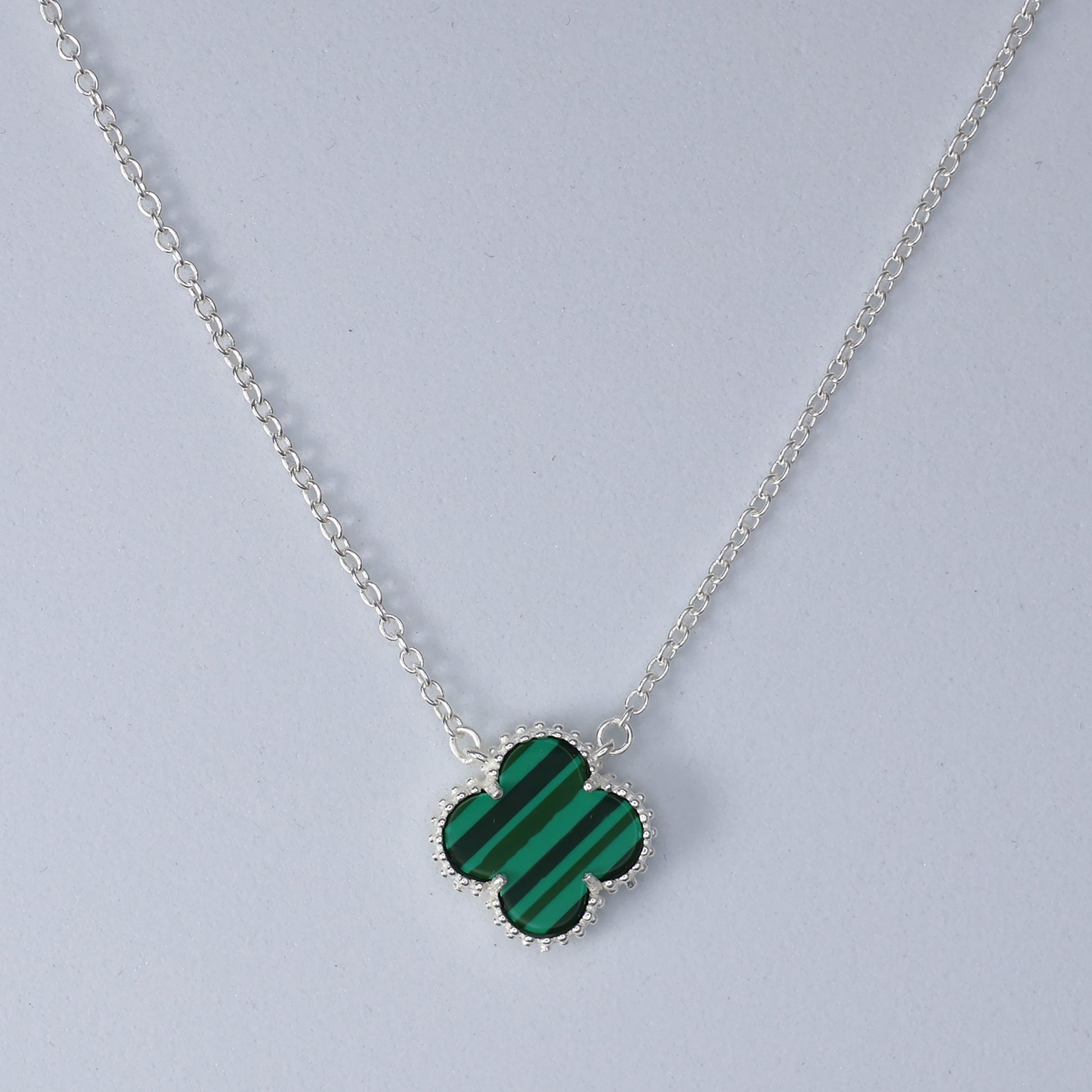 Malachite Clover Necklace featuring a green striped clover pendant on a silver chain.