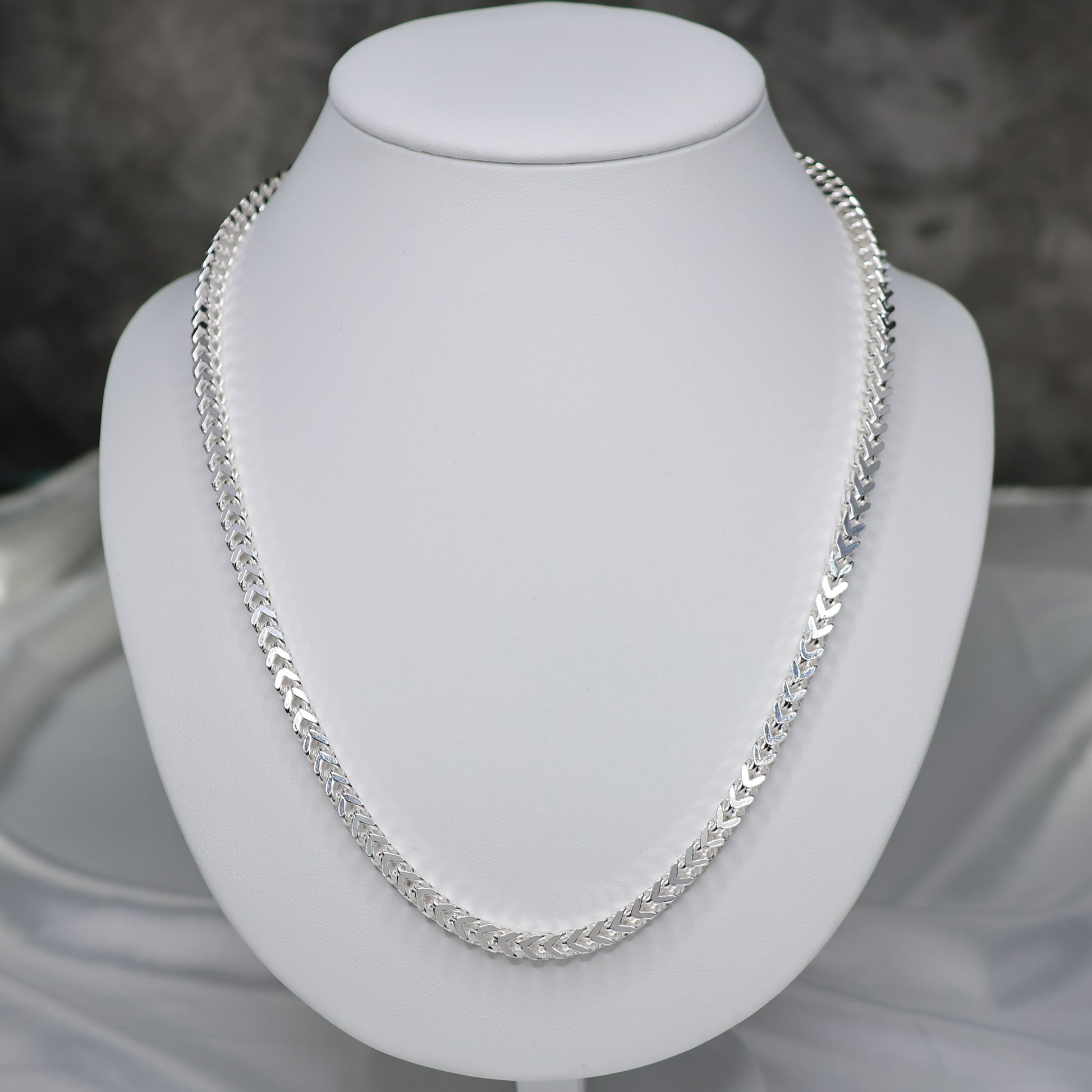 Men's Sterling Silver Franco Chain 22 inch displayed elegantly on a white bust stand