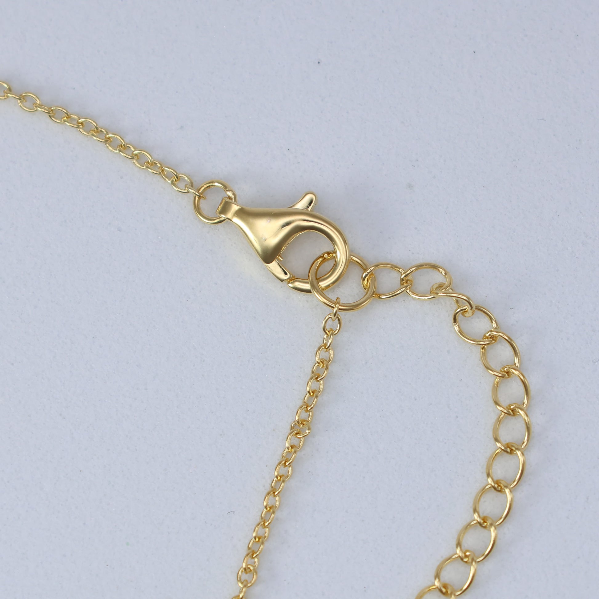 Close-up of a gold clasp on a delicate chain for Mother of Pearl Clover Necklace