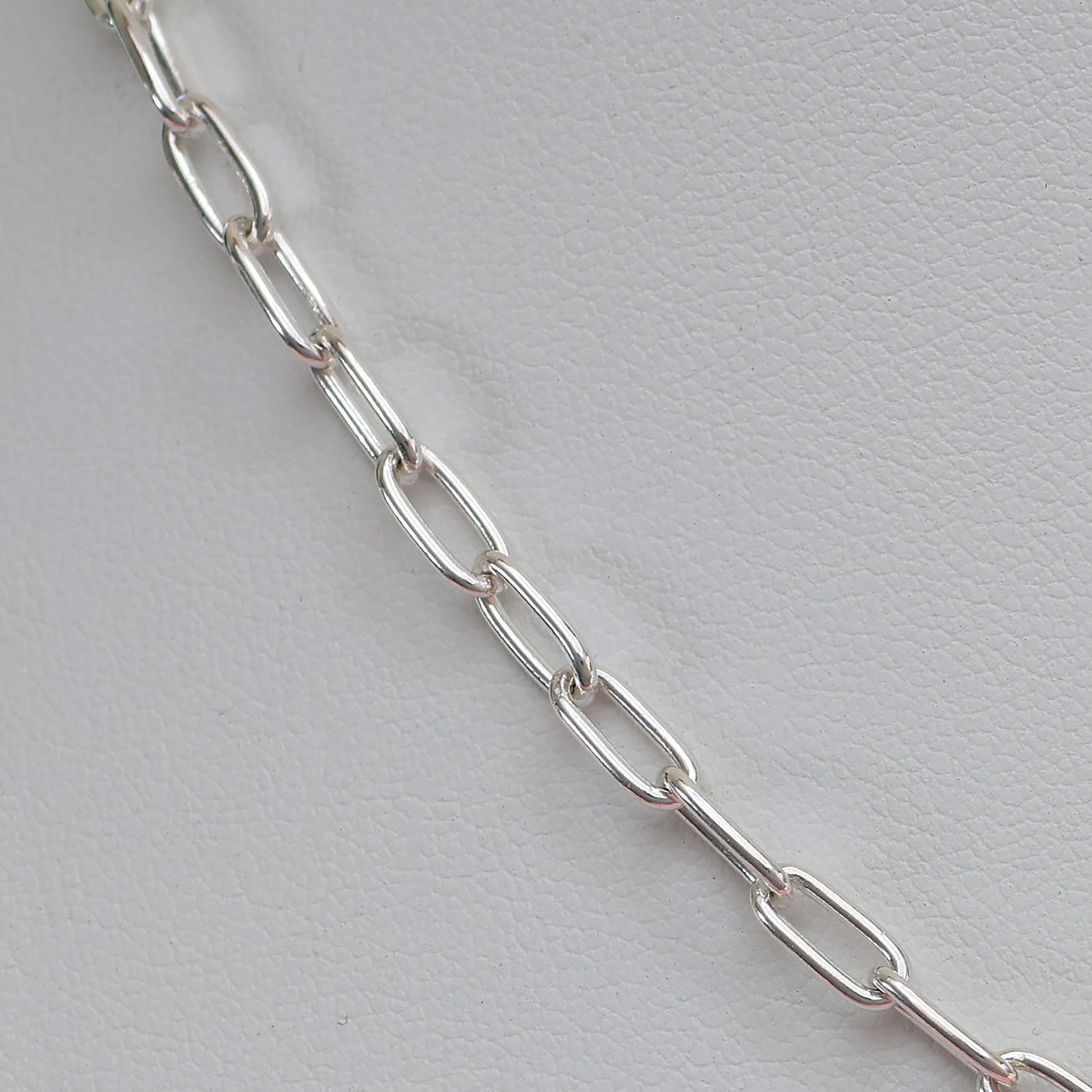 Close-up of a padlock clasp silver necklace with sleek, elongated chain links
